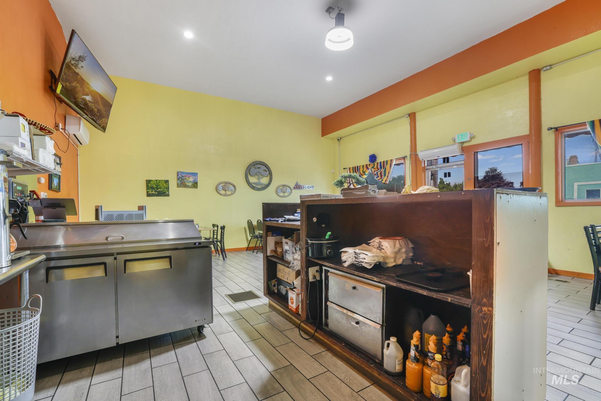 Kitchen featuring wood tiled floors, stainless steel counters, and recessed lighting
