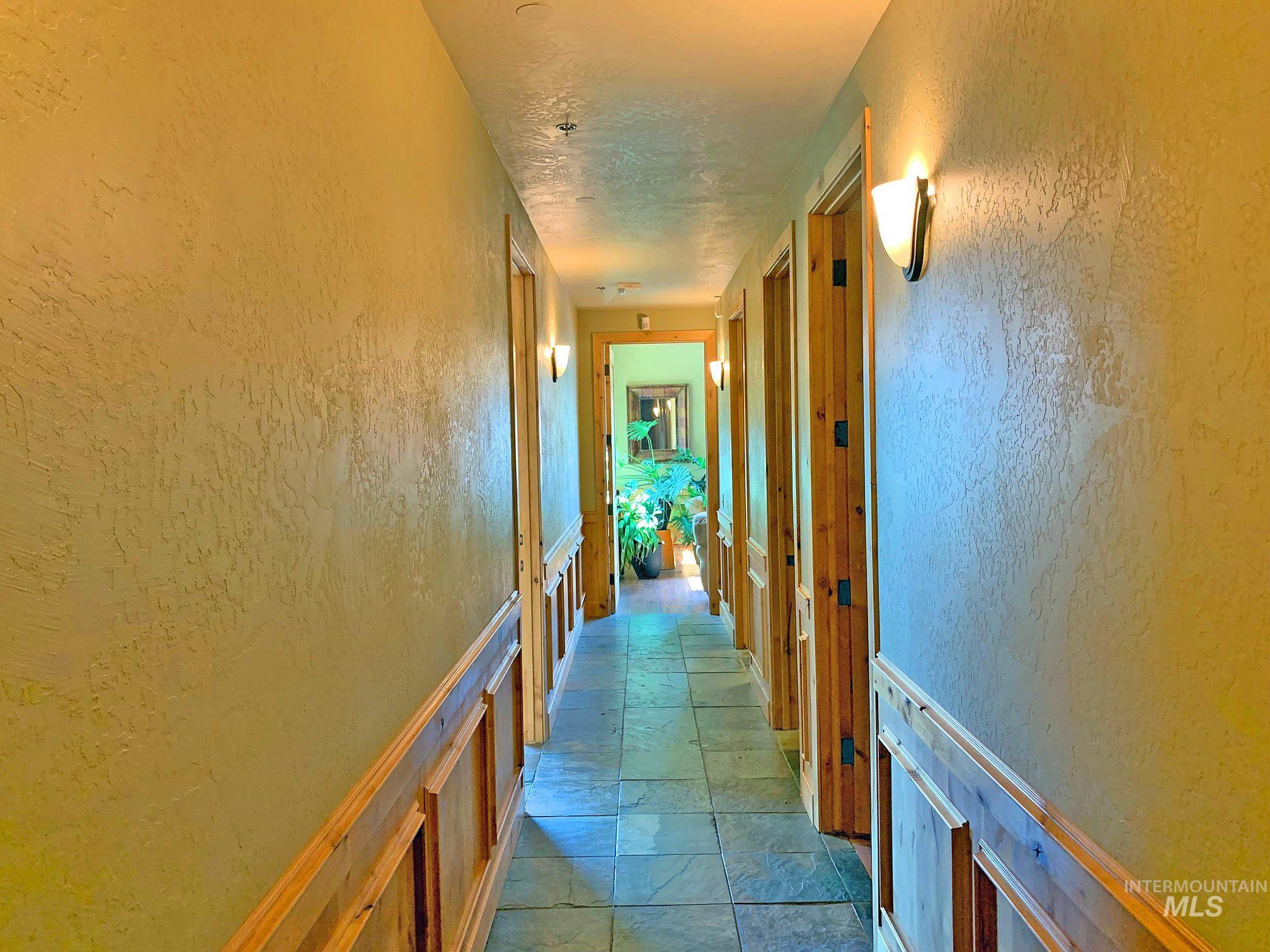 Corridor with a textured wall and stone tile flooring