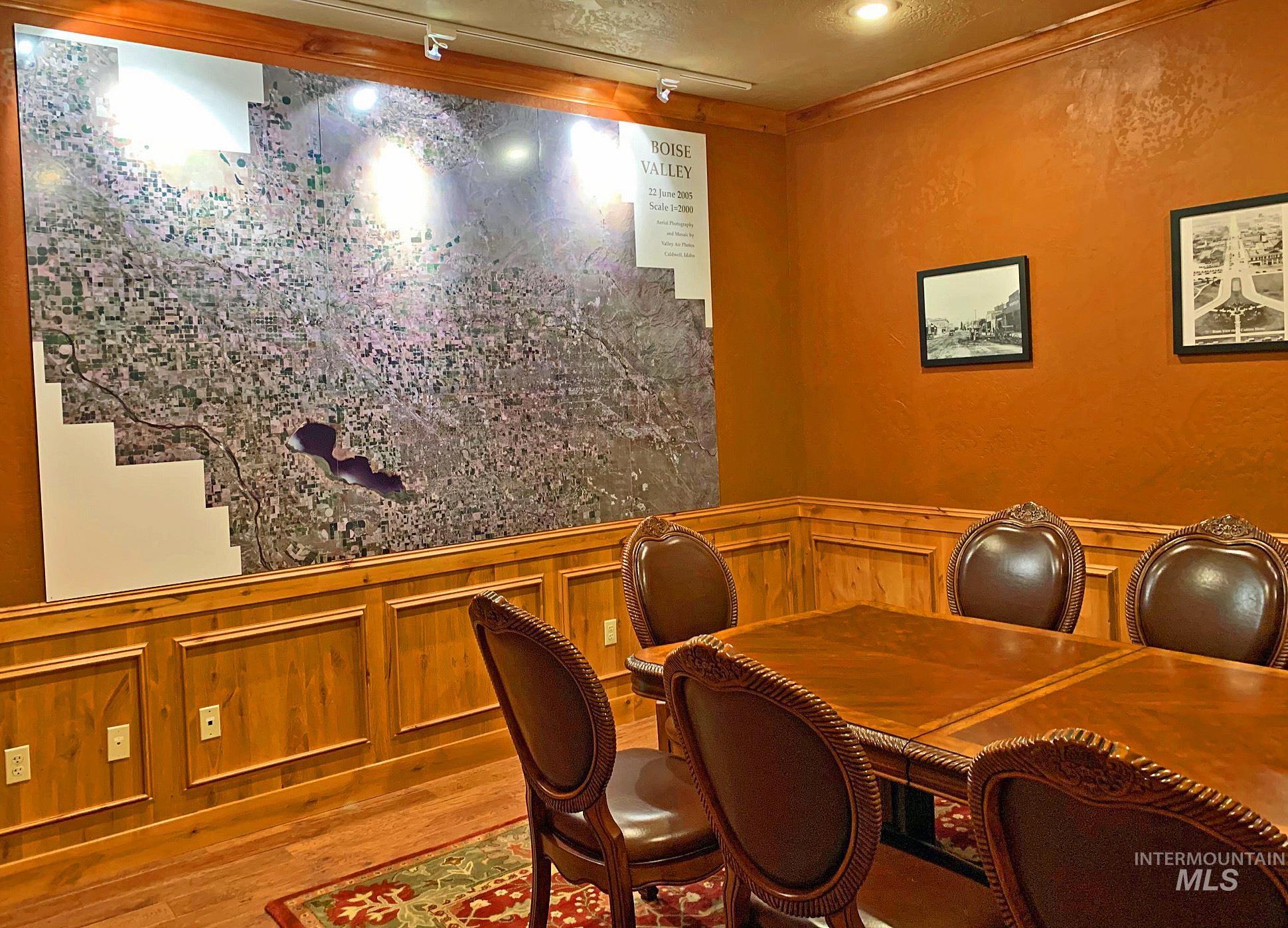 Office area with wainscoting, wood finished floors, a decorative wall, and rail lighting