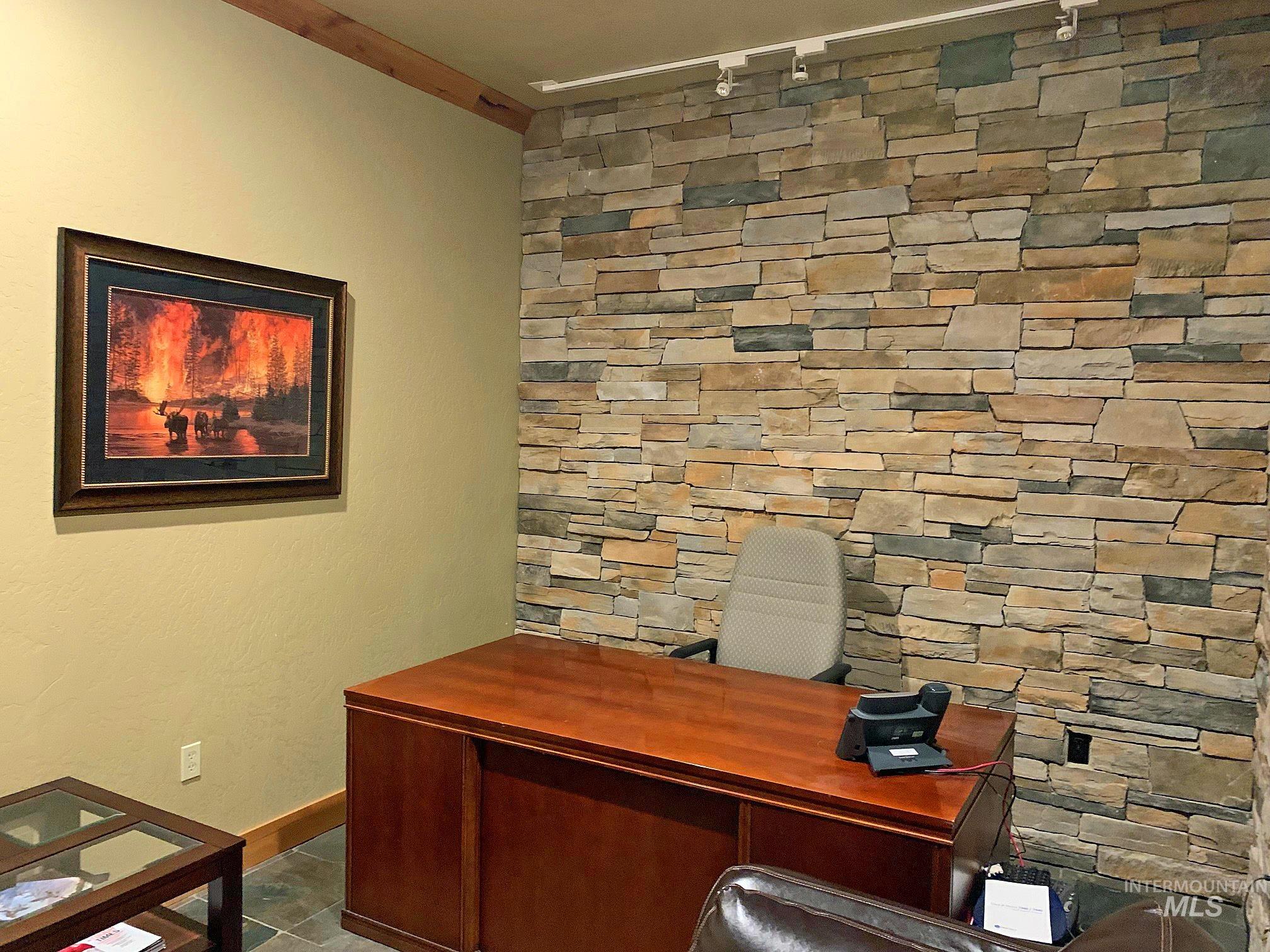Home office featuring track lighting and baseboards