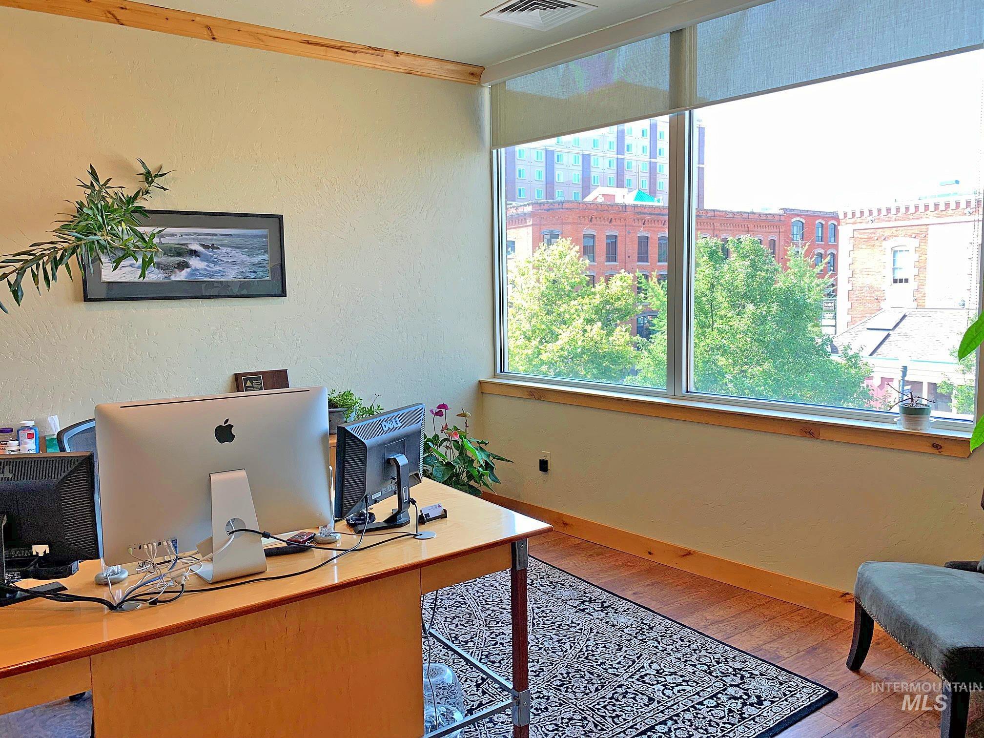 Home office with light wood-style flooring and crown molding