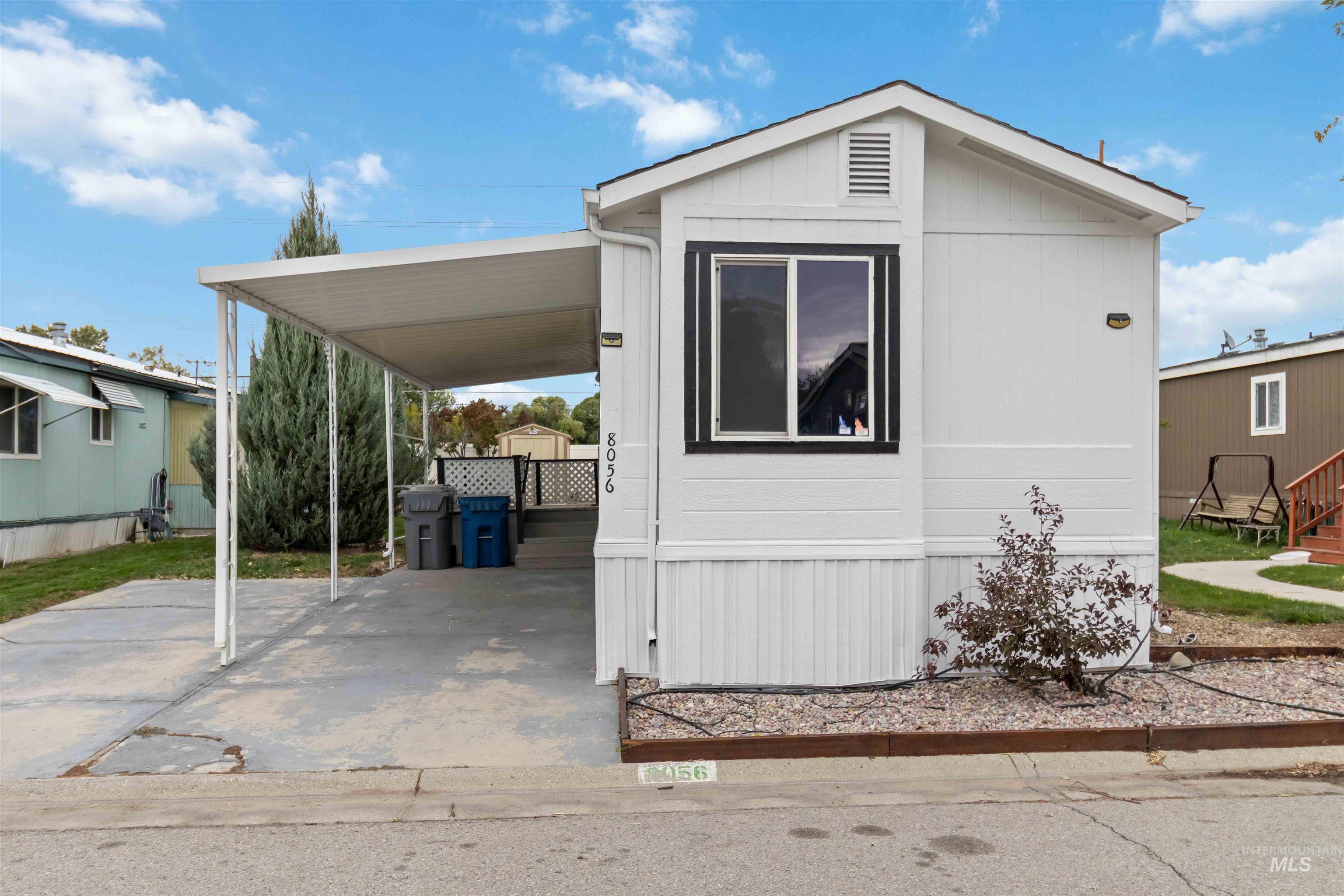View of front of house with concrete driveway and a carport