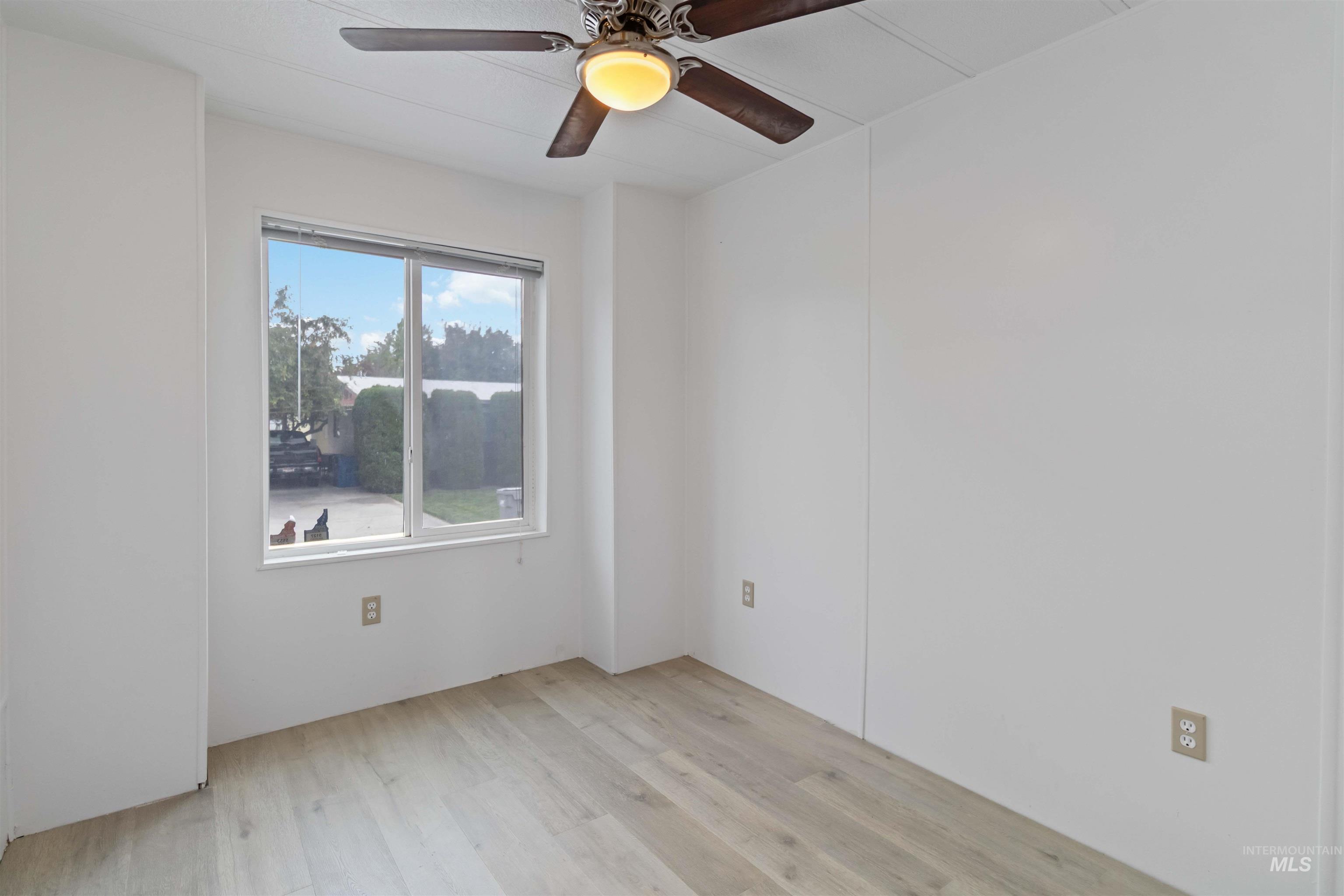 Spare room featuring light wood finished floors and ceiling fan