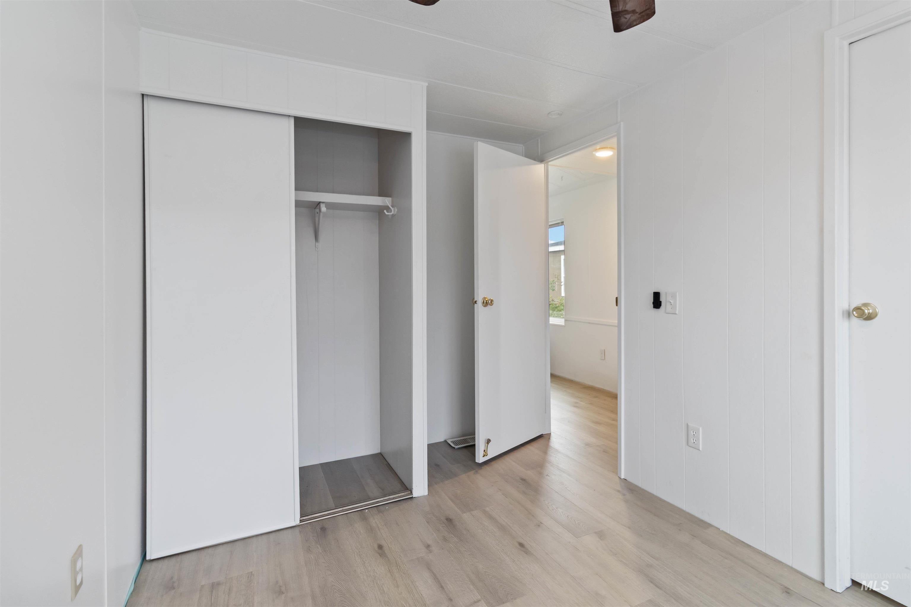 Unfurnished bedroom with light wood-style floors and a closet