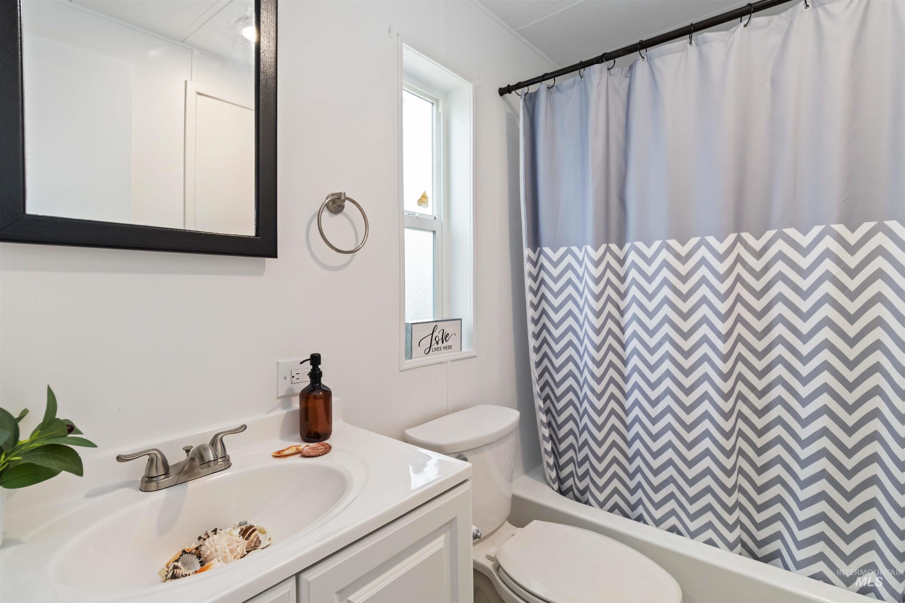 Bathroom with vanity and shower / bath combo with shower curtain