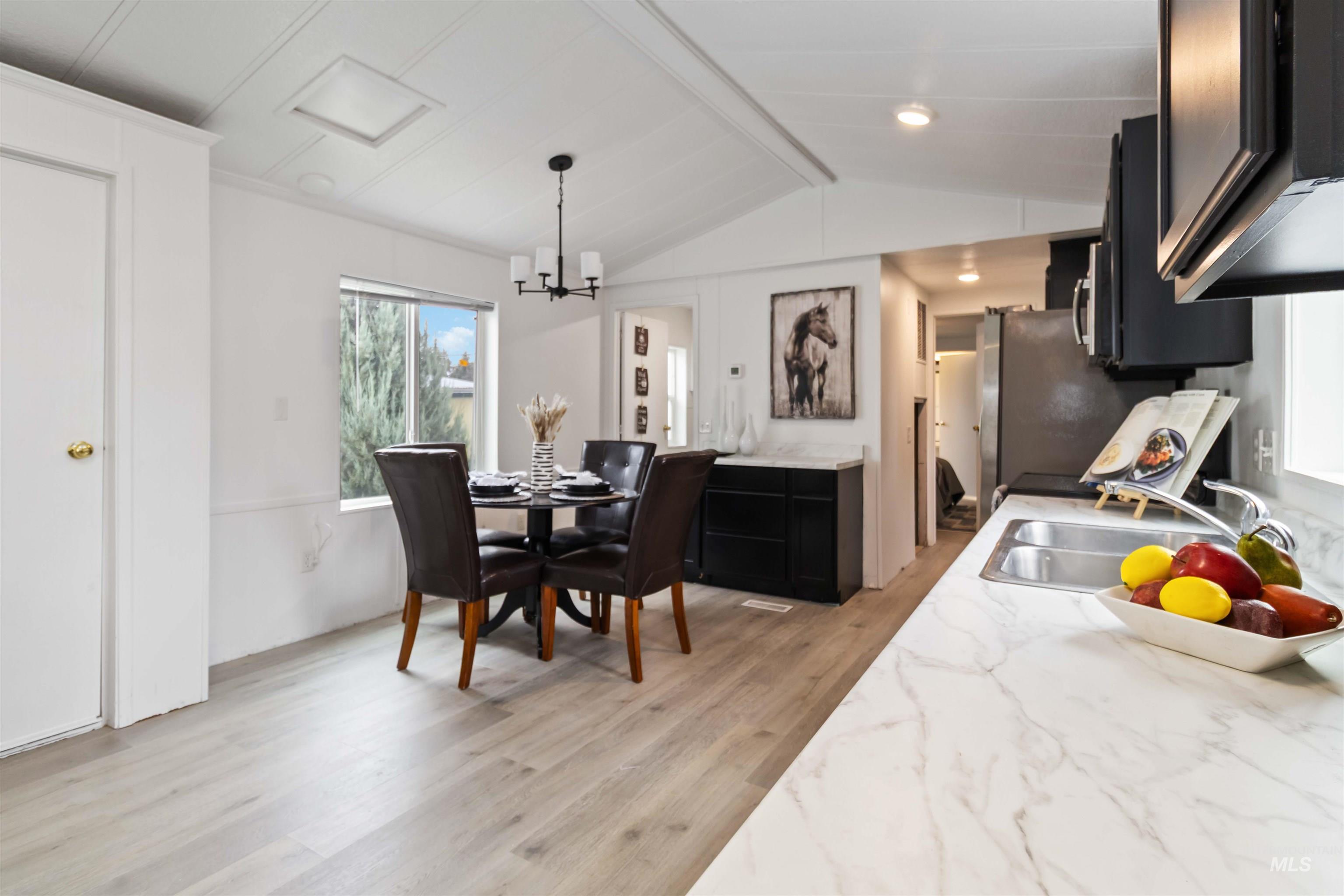 Dining area featuring light wood finished floors and a chandelier