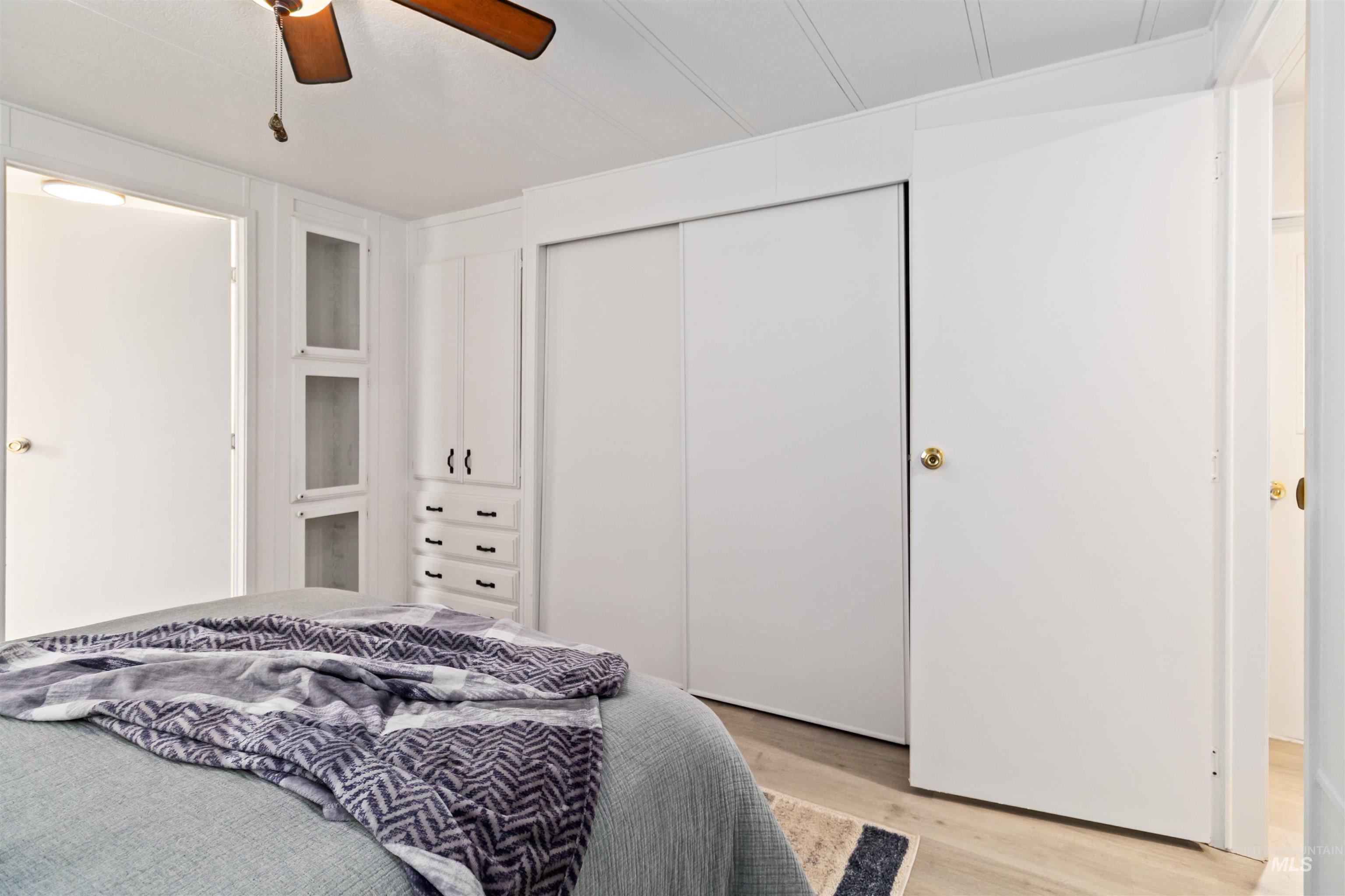 Bedroom featuring light wood-style flooring, a closet, and a ceiling fan
