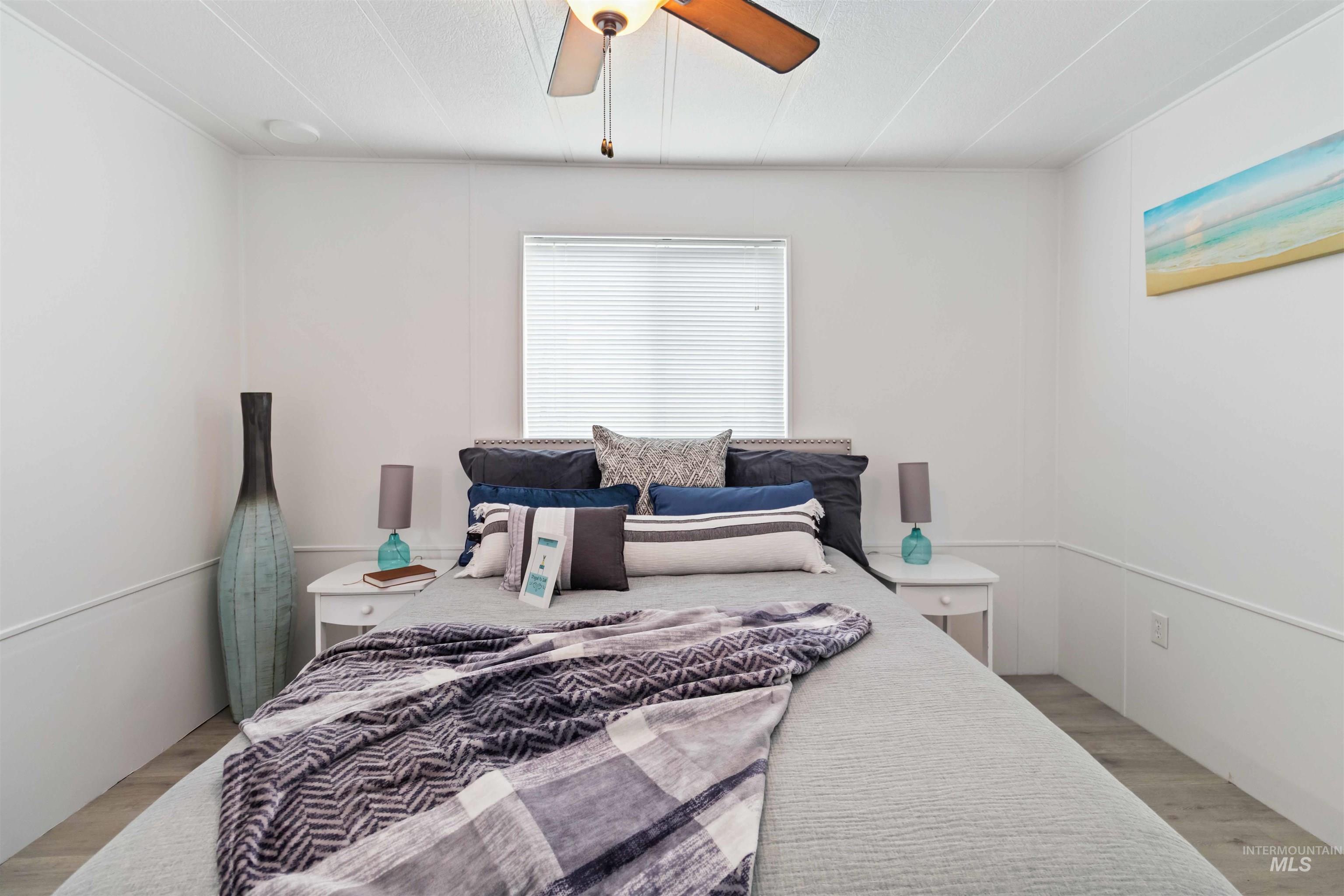 Bedroom with light wood-style floors and a ceiling fan