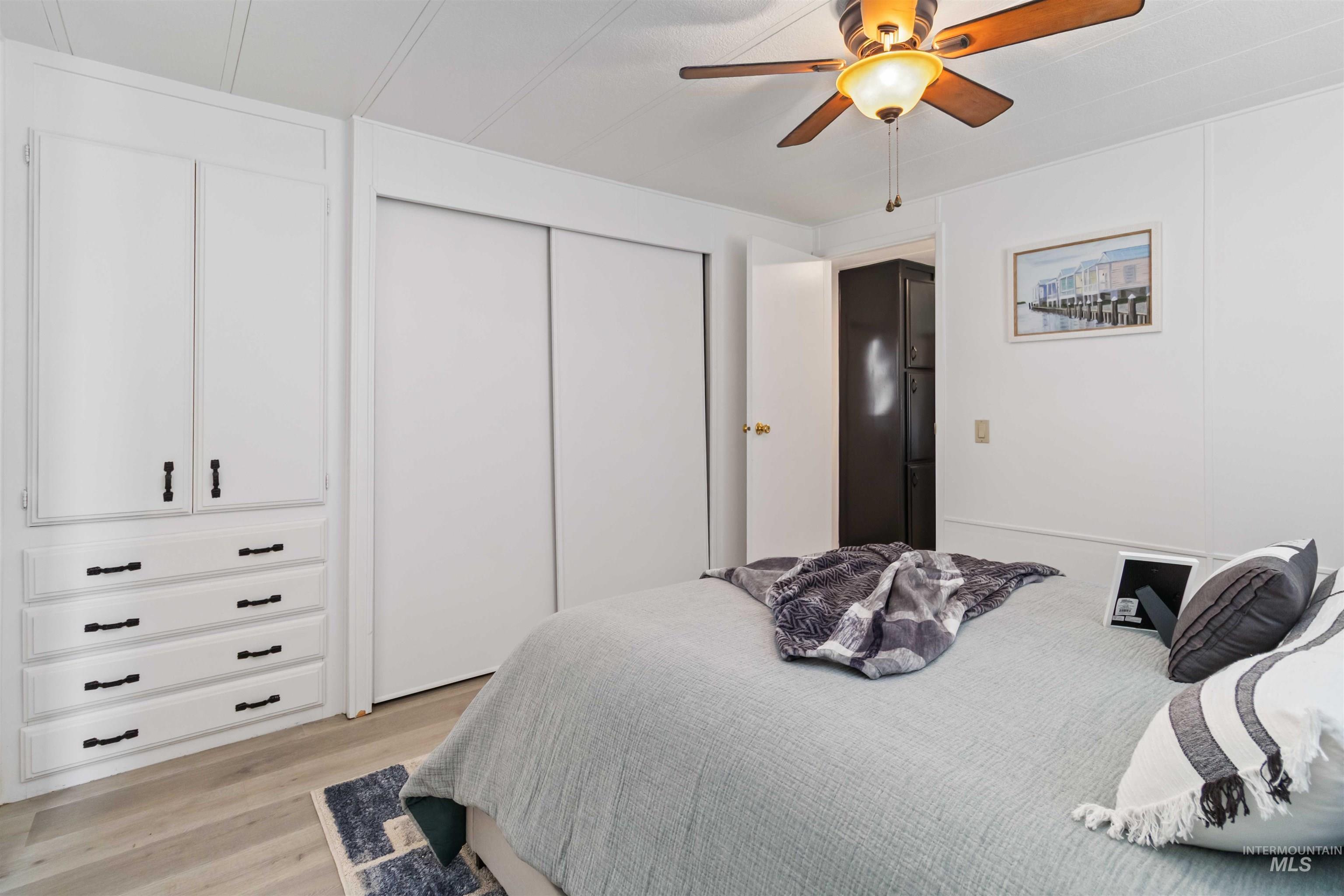 Bedroom with light wood-type flooring, a closet, and ceiling fan