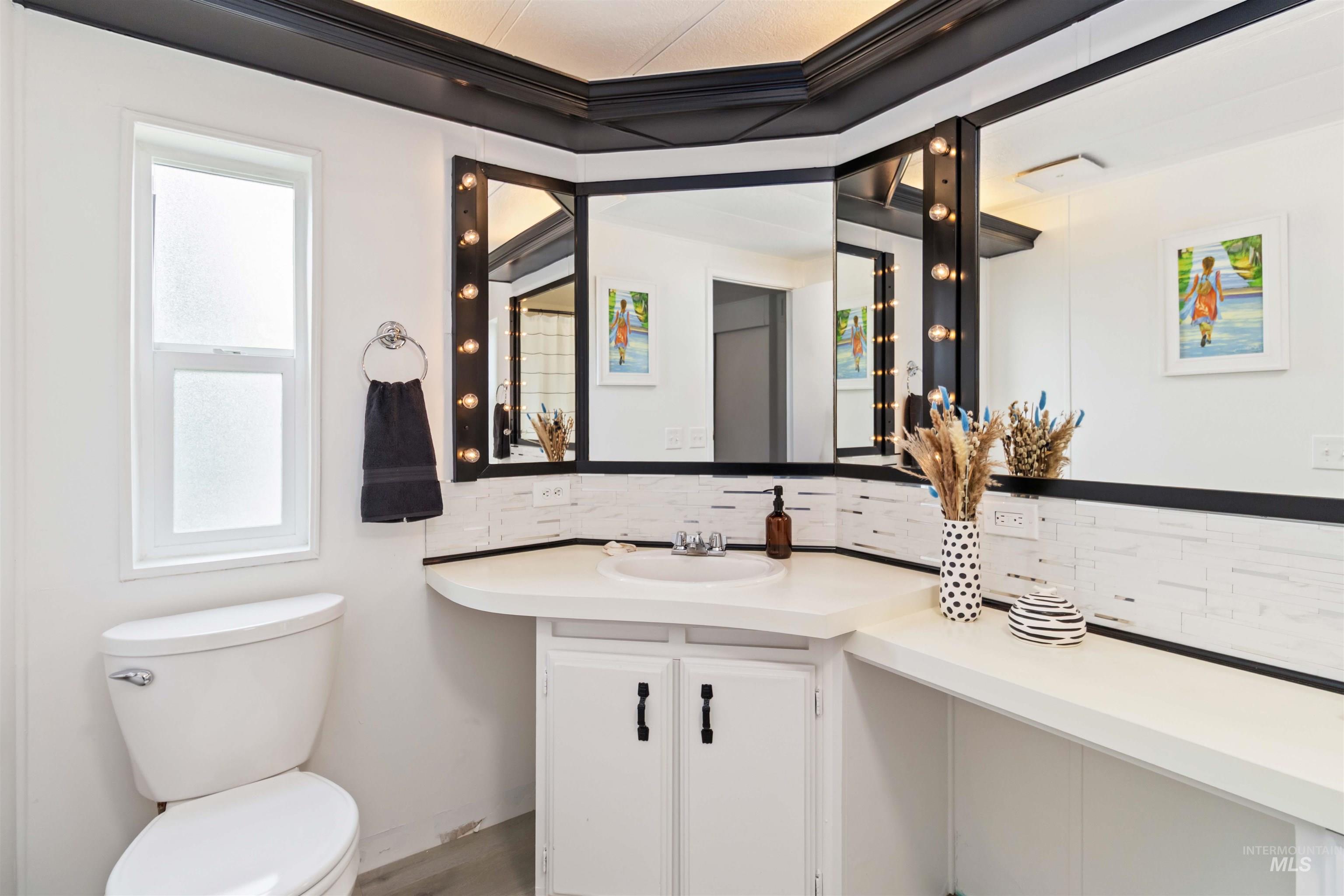 Half bathroom with backsplash, vanity, and ornamental molding