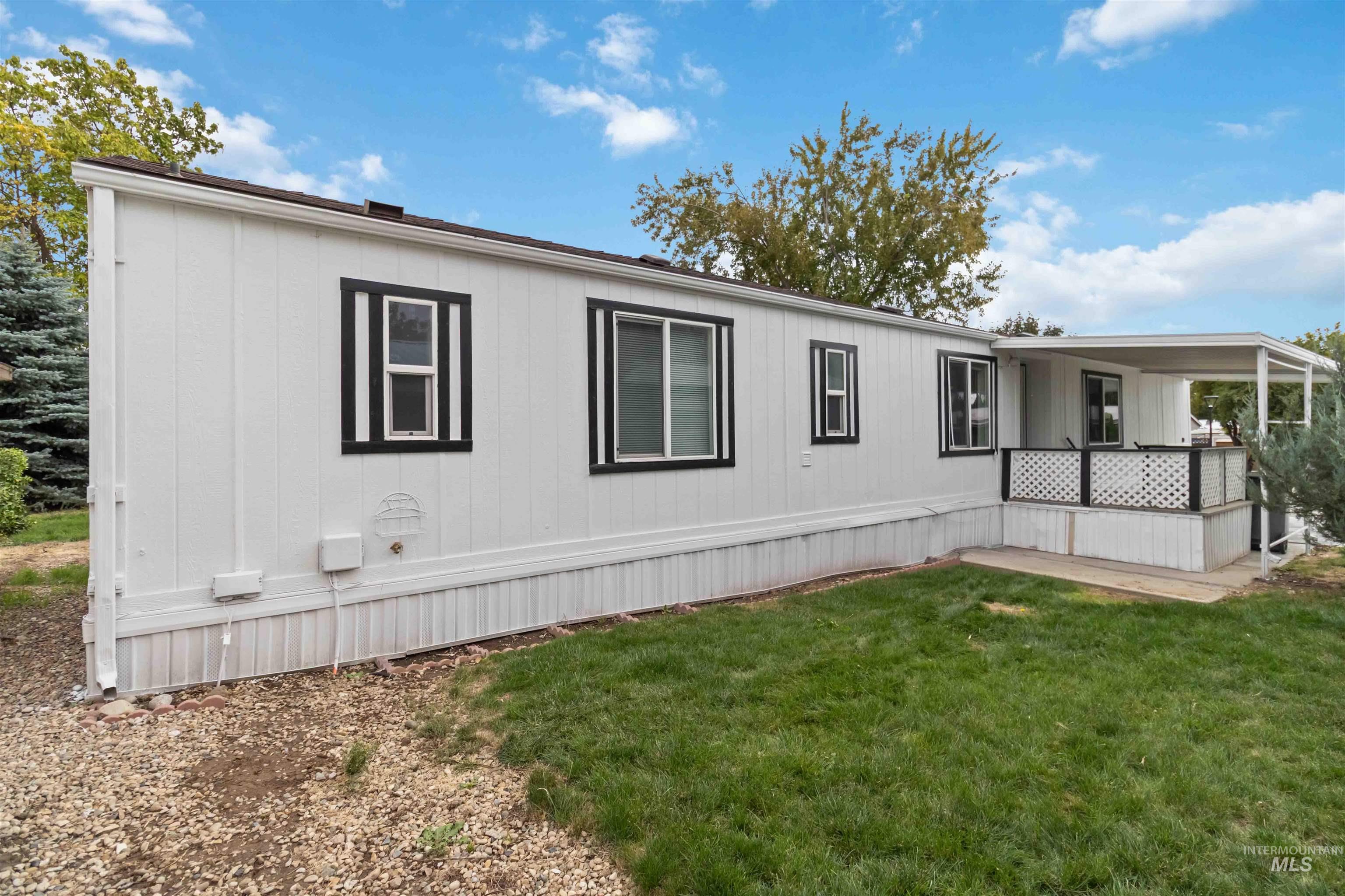 View of property exterior with a yard and a deck