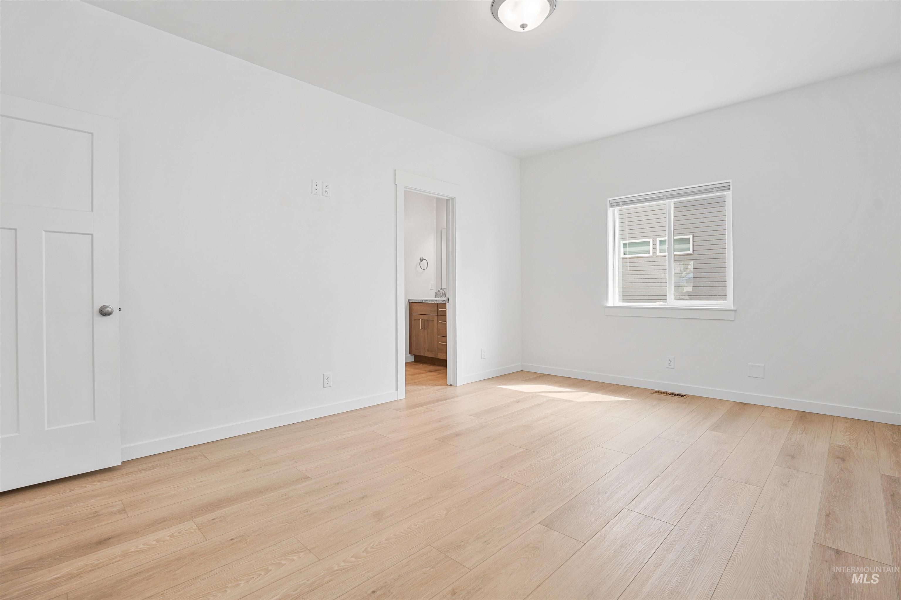 Unfurnished room featuring light wood-style floors and baseboards