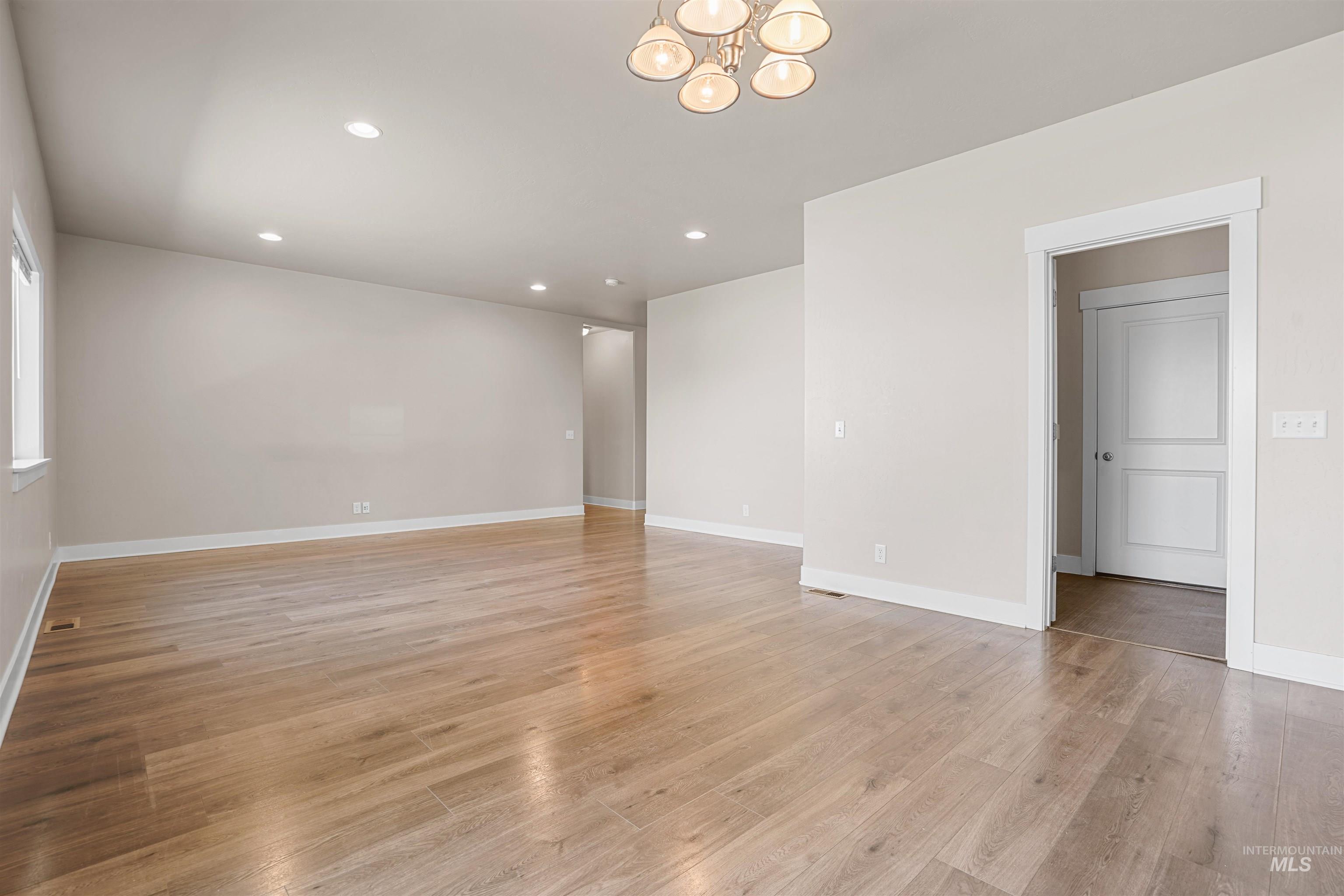 Unfurnished room featuring recessed lighting, a chandelier, and light wood-style flooring