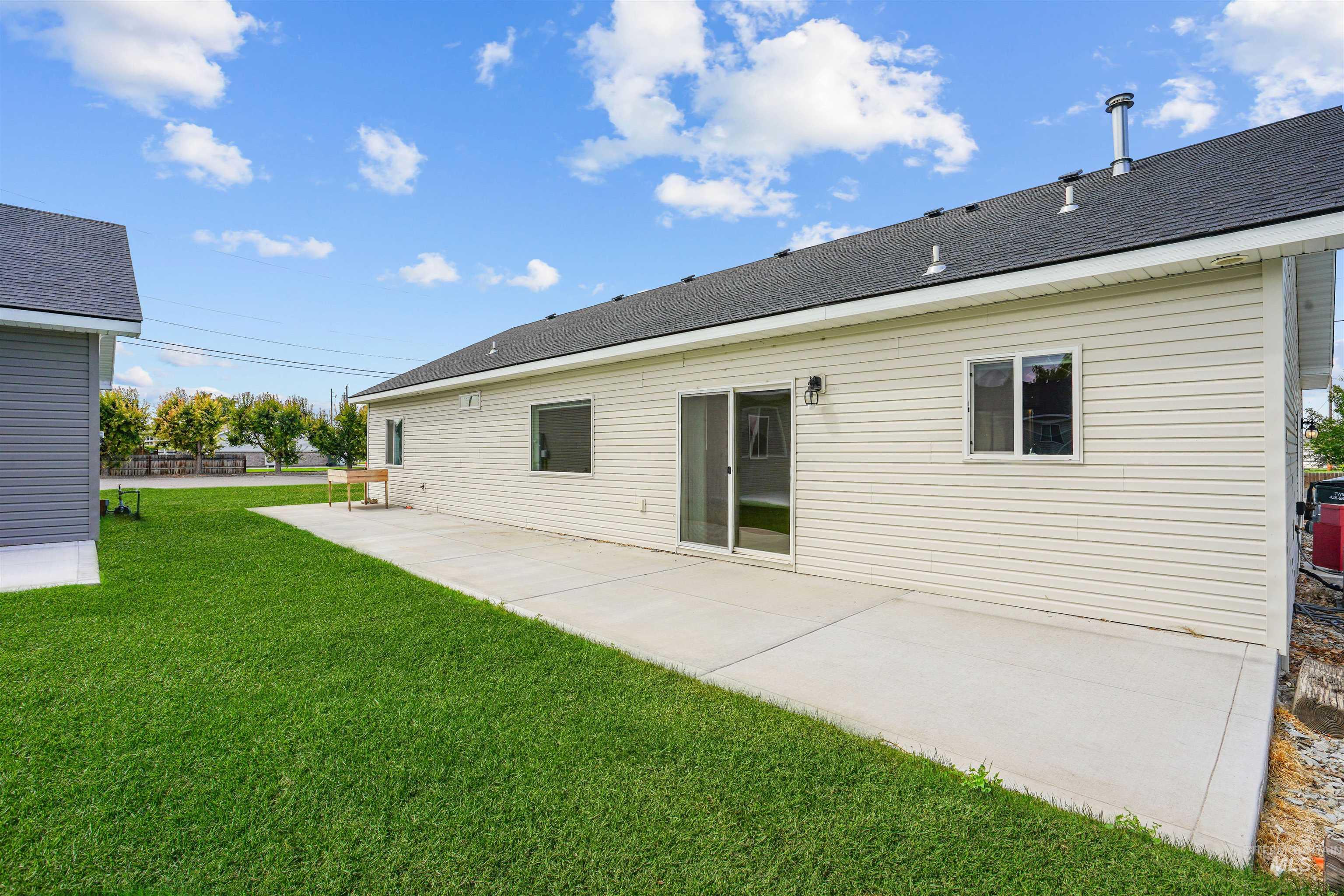 Back of house featuring a patio, roof with shingles, and a lawn