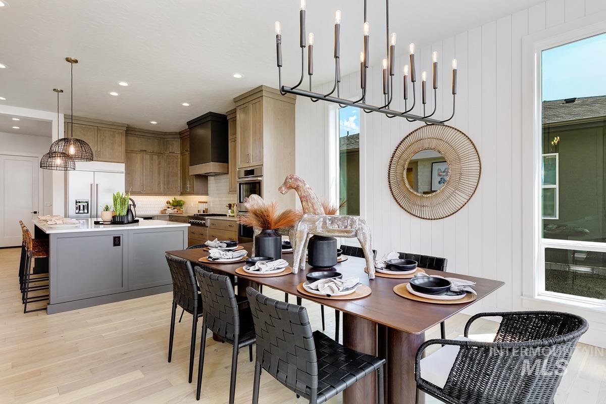 Dining space with light wood-style floors, a chandelier, wood walls, and recessed lighting