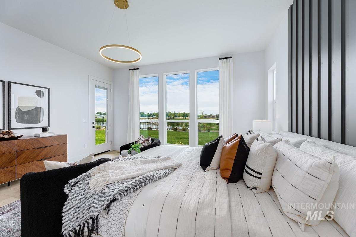 Bedroom with multiple windows, a water view, and access to outside