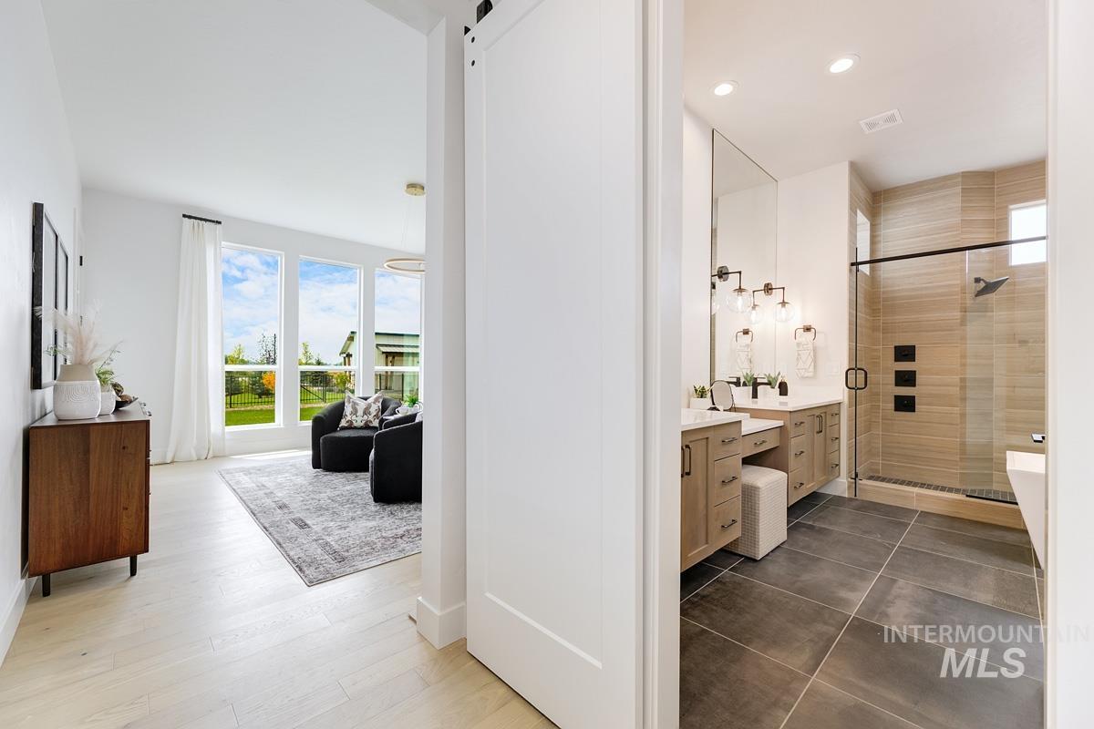 Full bathroom featuring vanity, a stall shower, and recessed lighting