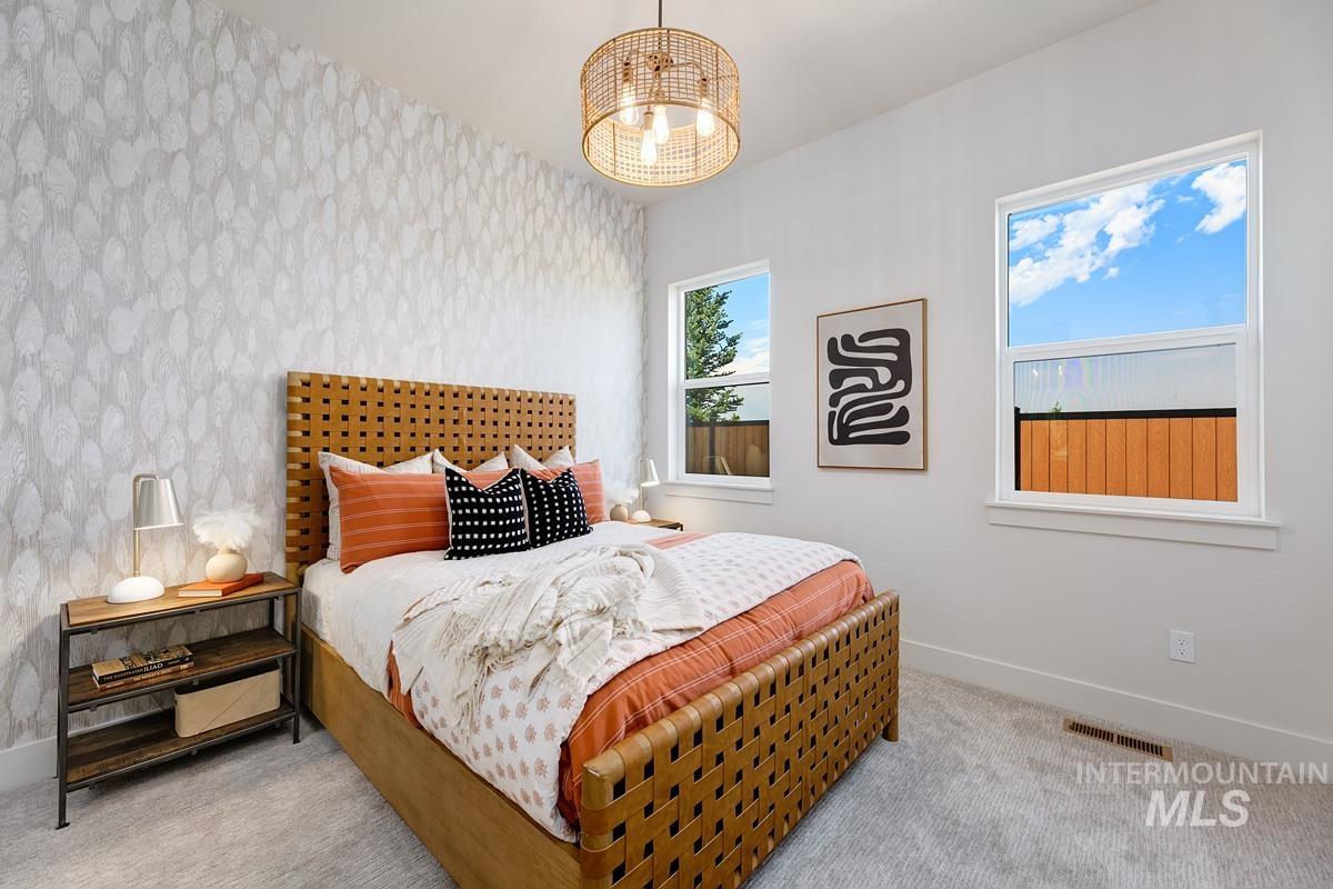 Bedroom with carpet flooring, wallpapered walls, and an accent wall