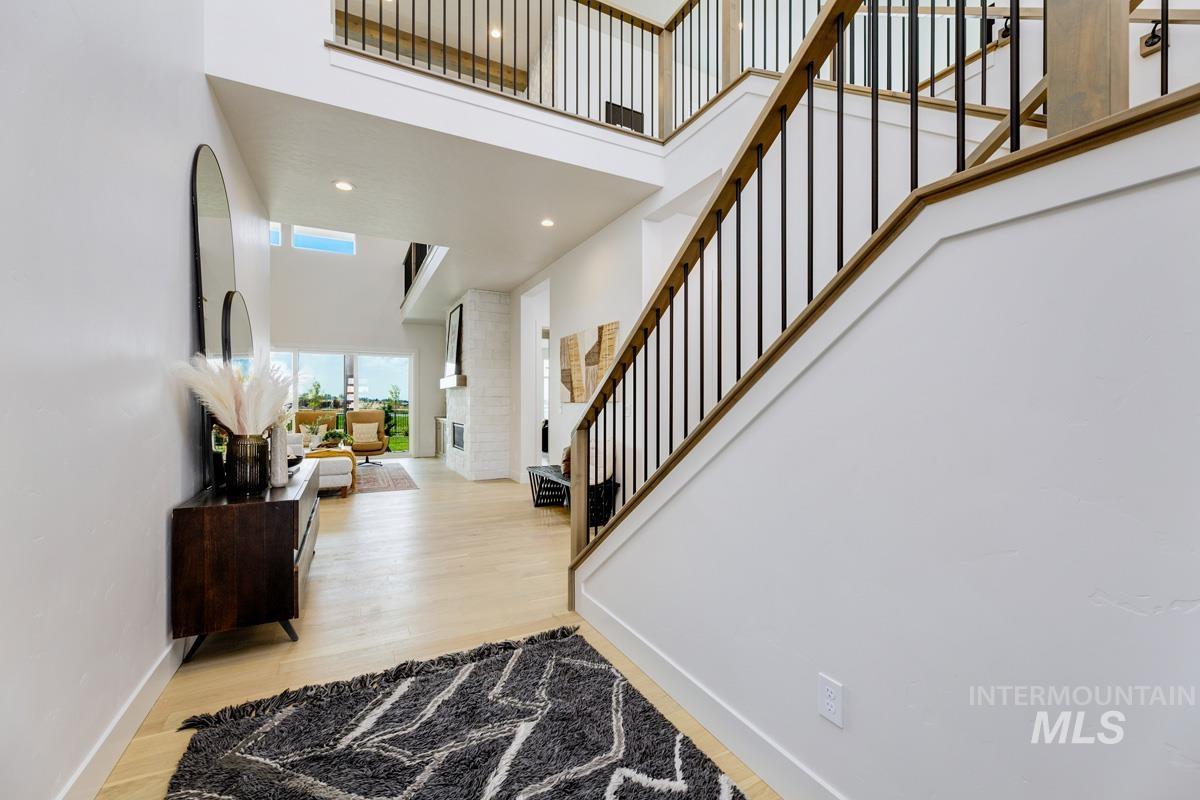 Entryway featuring a high ceiling, recessed lighting, light wood-type flooring, and stairs