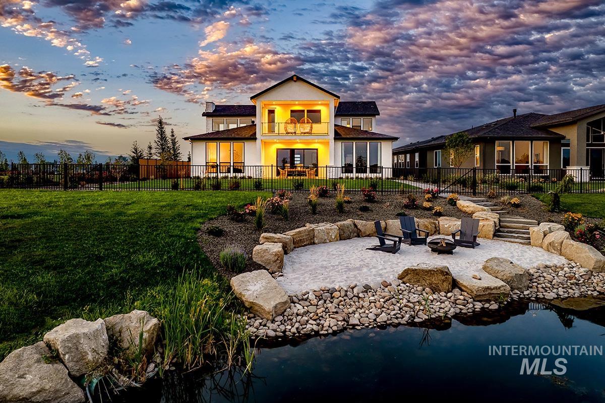 Back of house featuring an outdoor fire pit, a patio, a fenced backyard, and a balcony