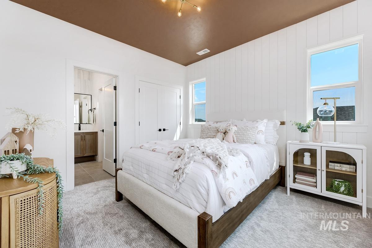 Carpeted bedroom featuring ensuite bathroom