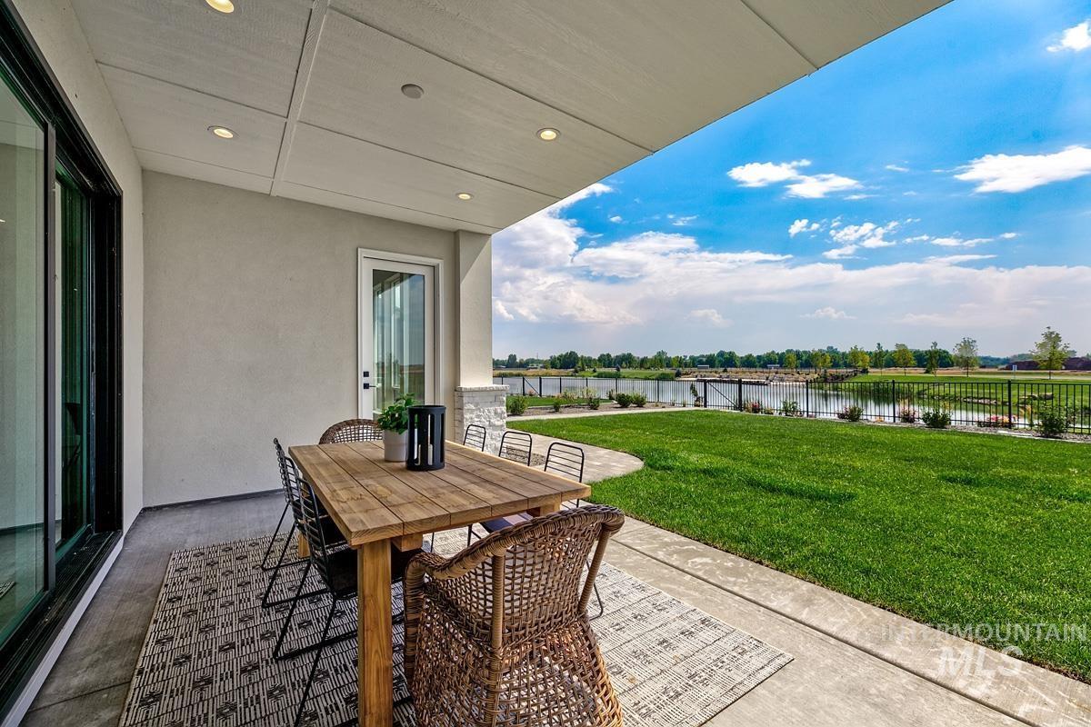 Fenced backyard with a patio, outdoor dining area, and a water view