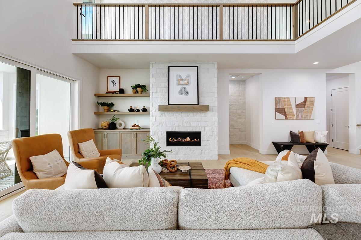Living area featuring a towering ceiling, wood finished floors, a large fireplace, and recessed lighting