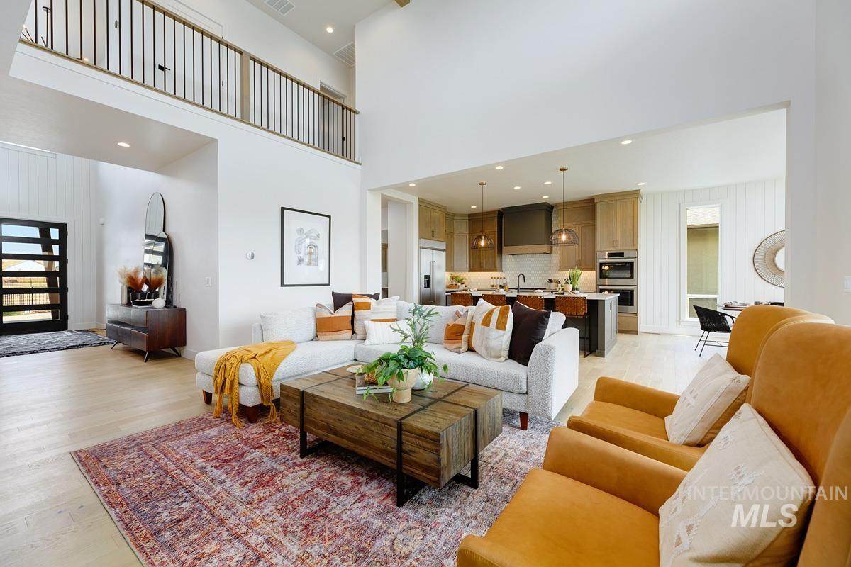 Living area featuring light wood-type flooring, recessed lighting, and a high ceiling