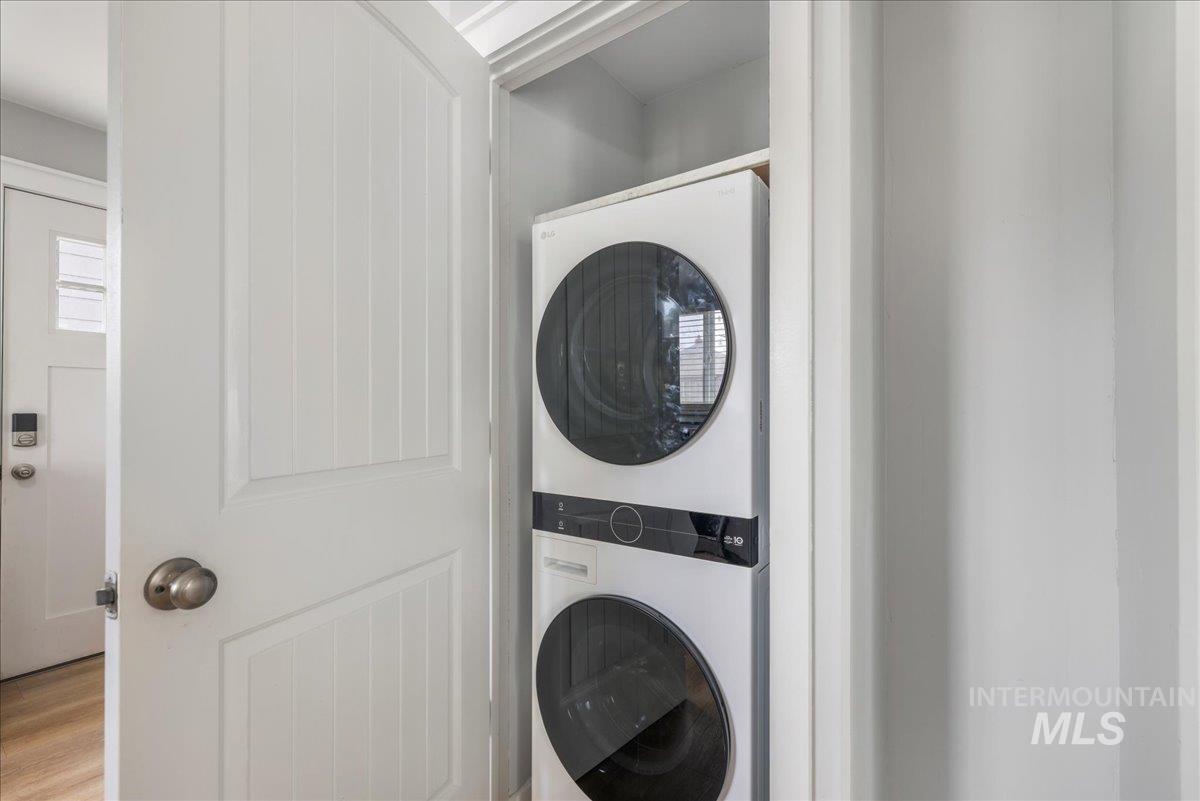 Washroom featuring stacked washer / drying machine