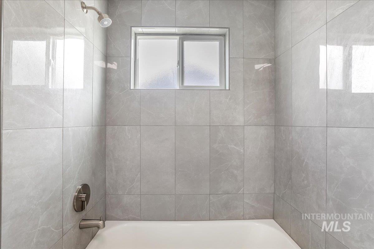 Full bath featuring shower / washtub combination