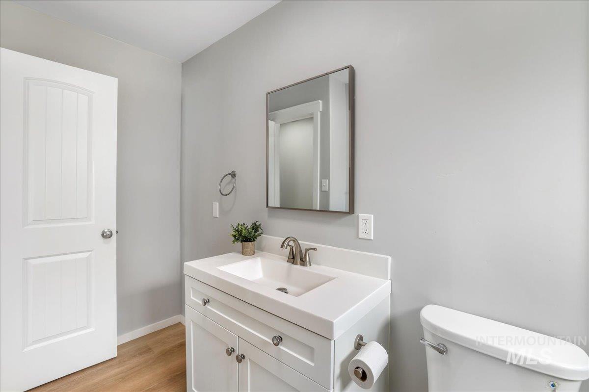 Half bath with vanity and light wood-style floors