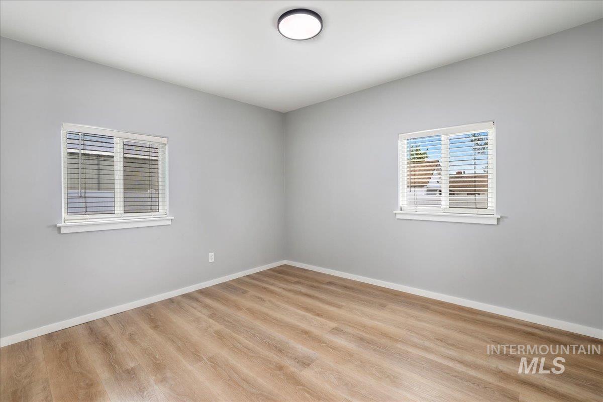 Spare room with baseboards and light wood-type flooring