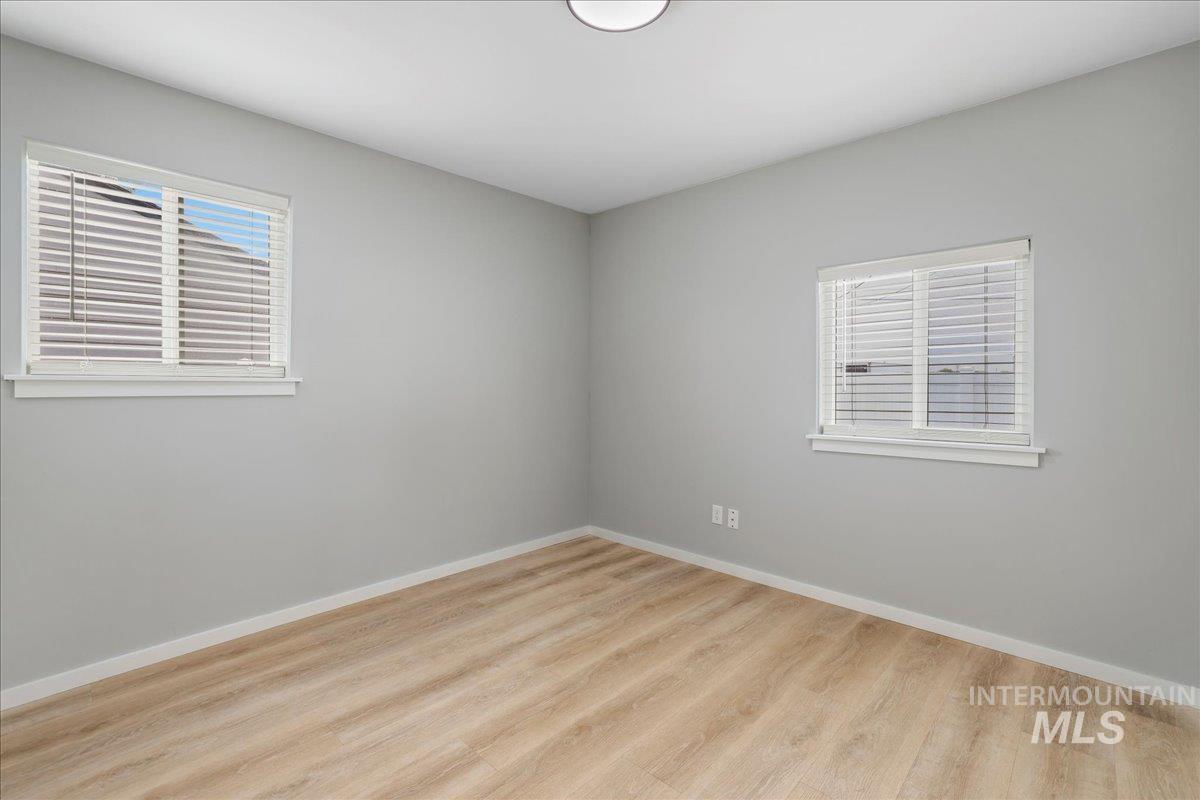 Spare room featuring light wood-type flooring and healthy amount of natural light