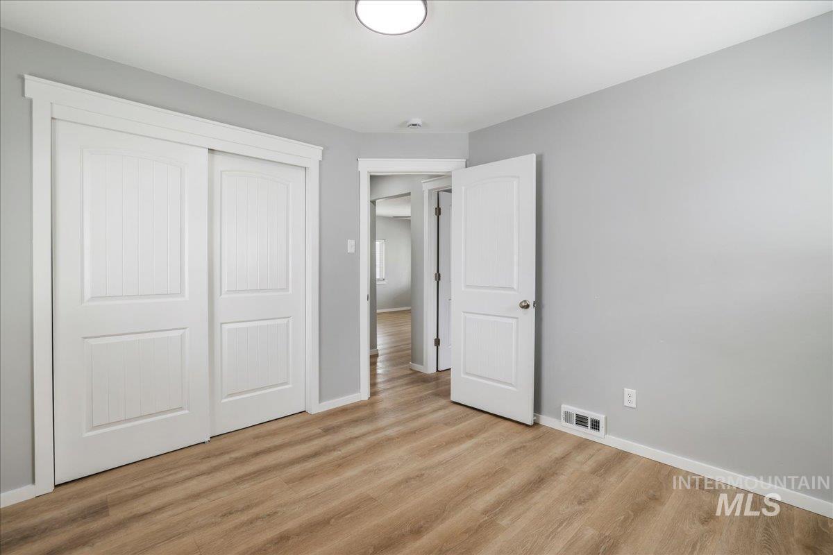 Unfurnished bedroom featuring a closet and light wood-type flooring