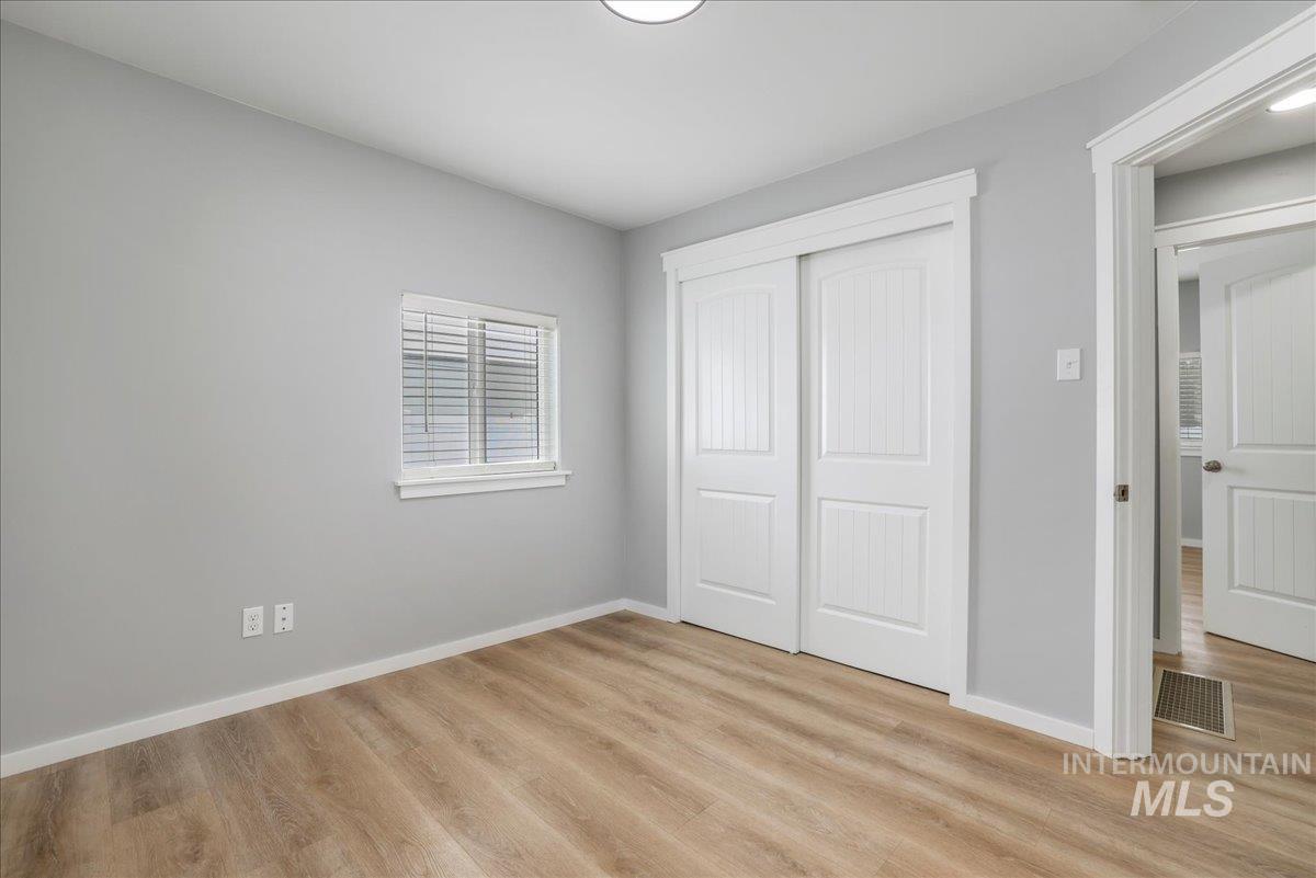 Unfurnished bedroom with light wood-type flooring and a closet