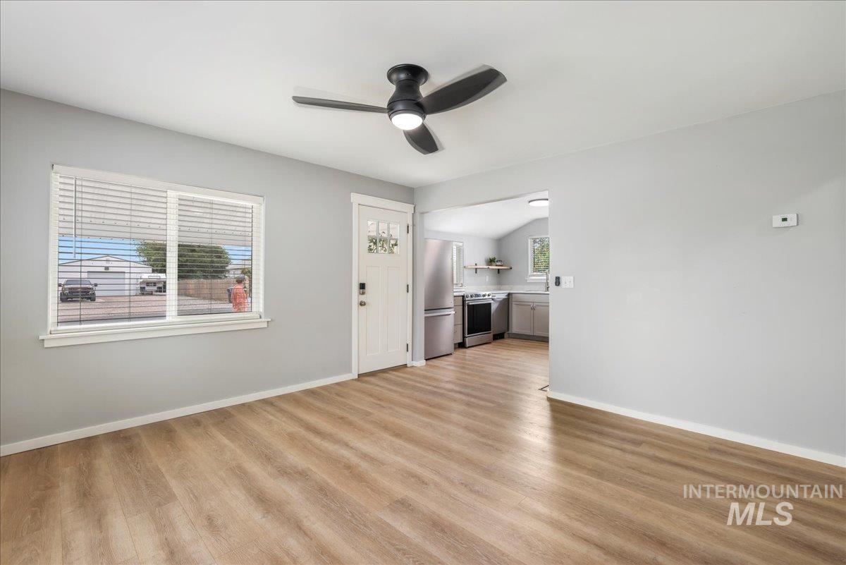 Unfurnished living room with light wood-style flooring and a ceiling fan