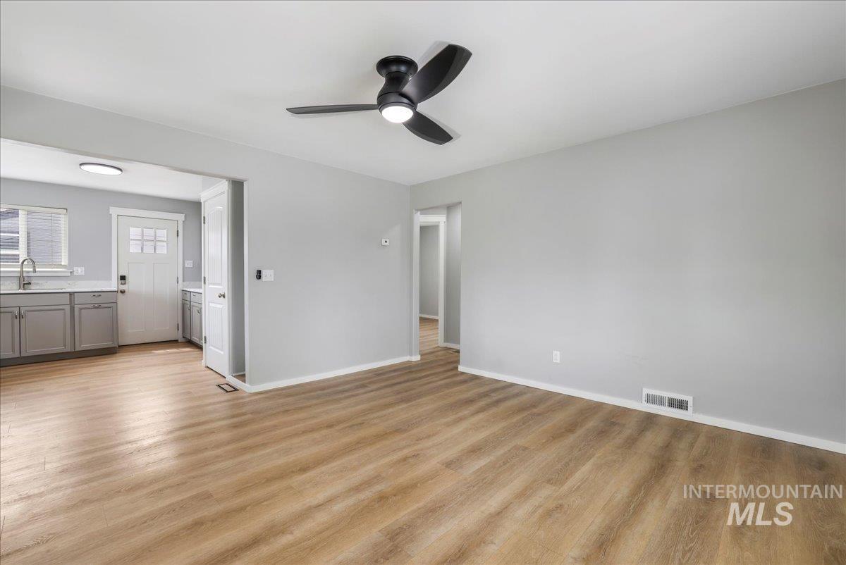 Unfurnished living room featuring light wood finished floors and ceiling fan