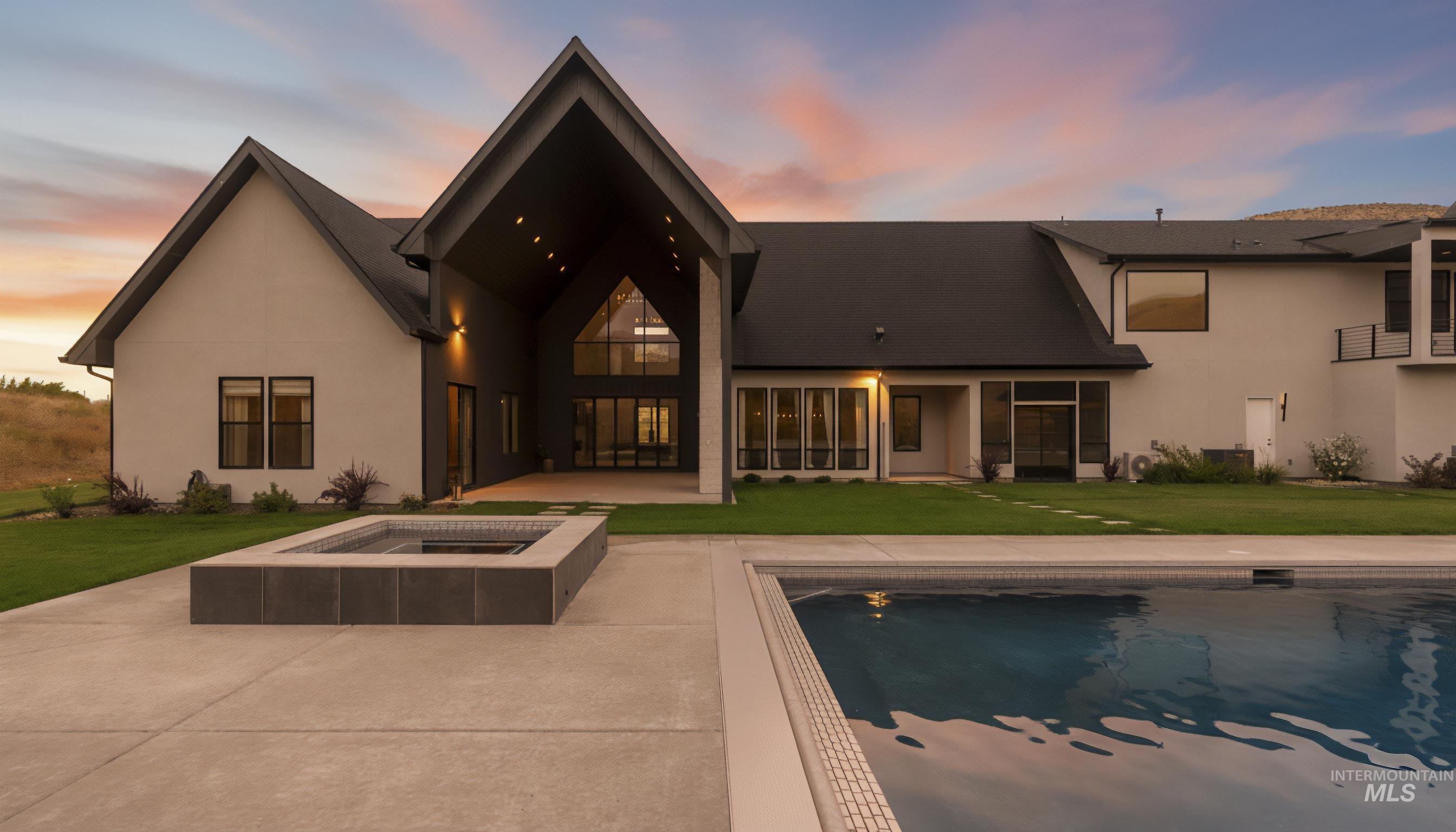 Rear view of house featuring a lawn, a patio area, an outdoor pool, and stucco siding