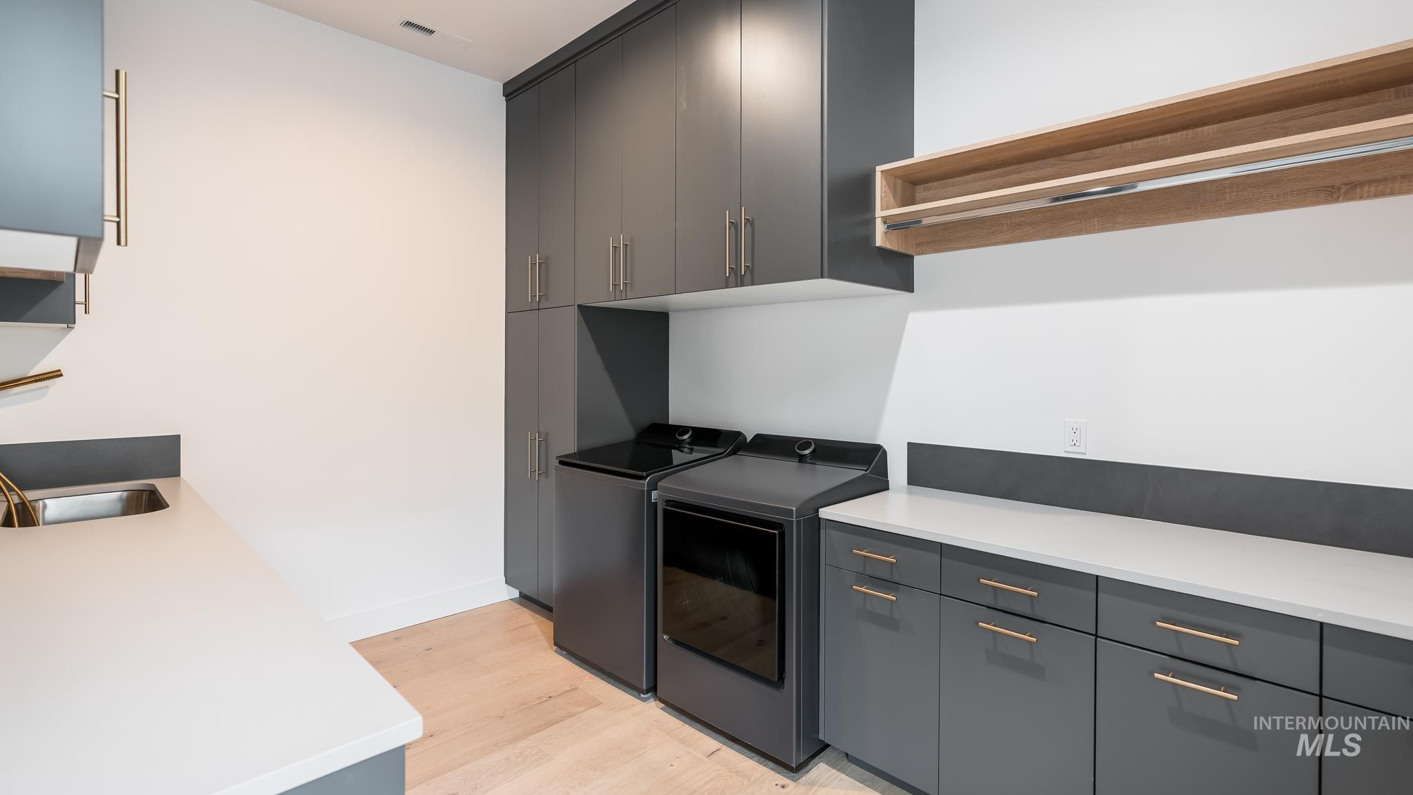 Laundry room with light wood-type flooring and washer and clothes dryer