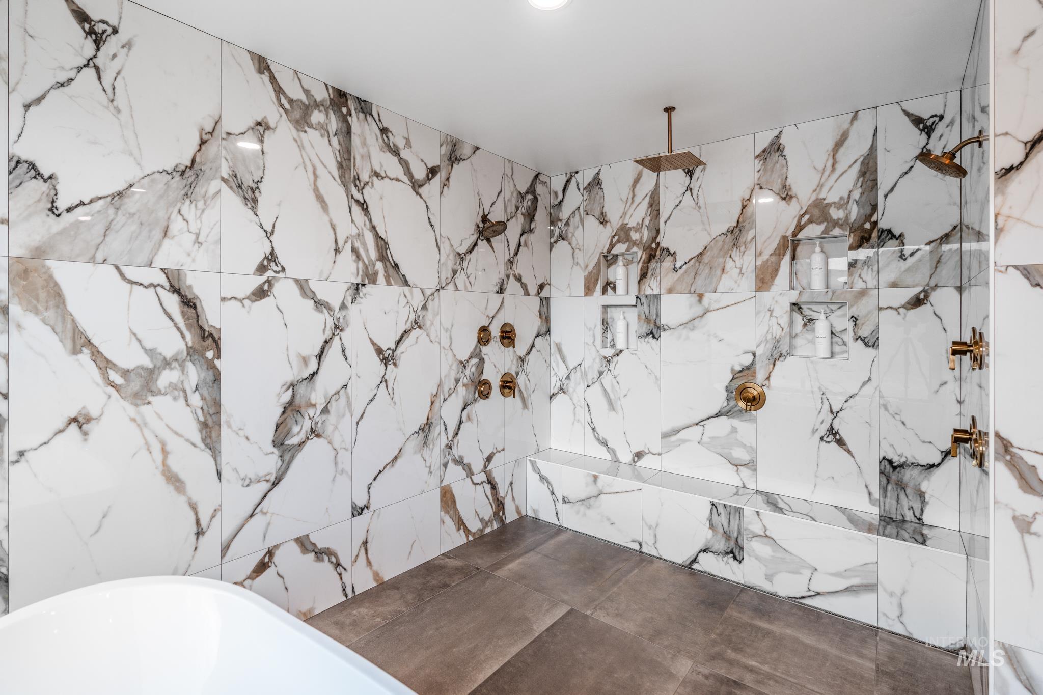 Full bathroom with a soaking tub and a marble finish shower