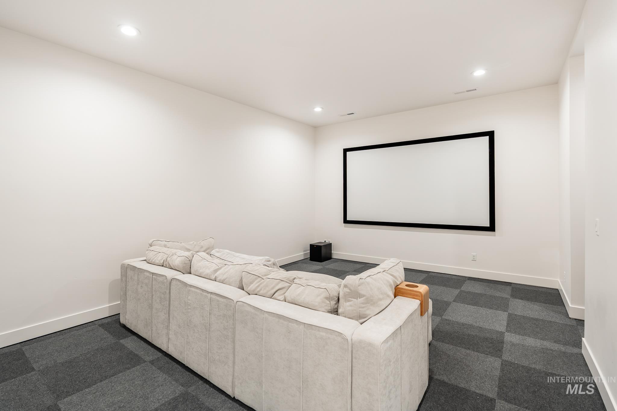 Home theater with recessed lighting and dark carpet