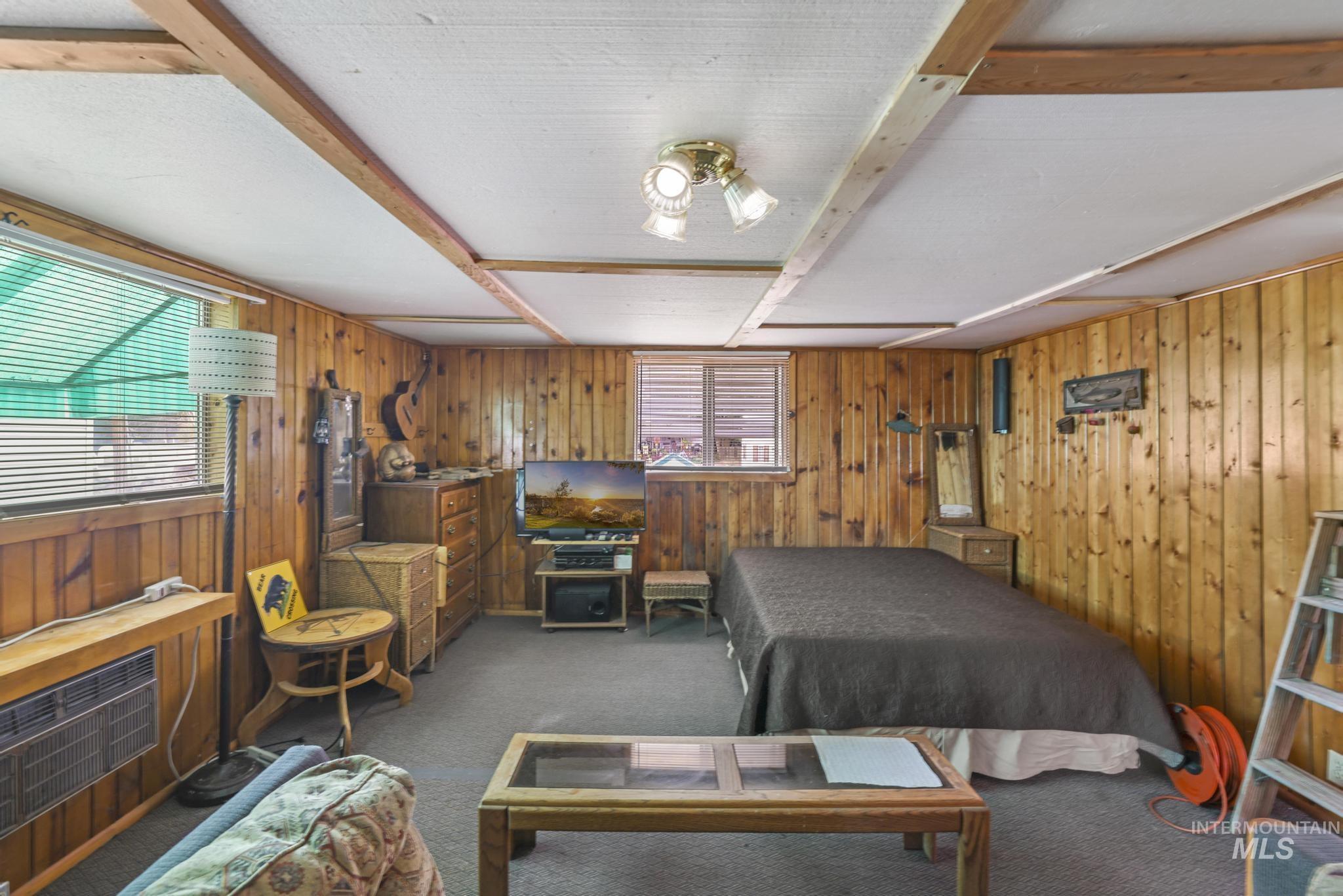 Bedroom with carpet flooring and wood walls