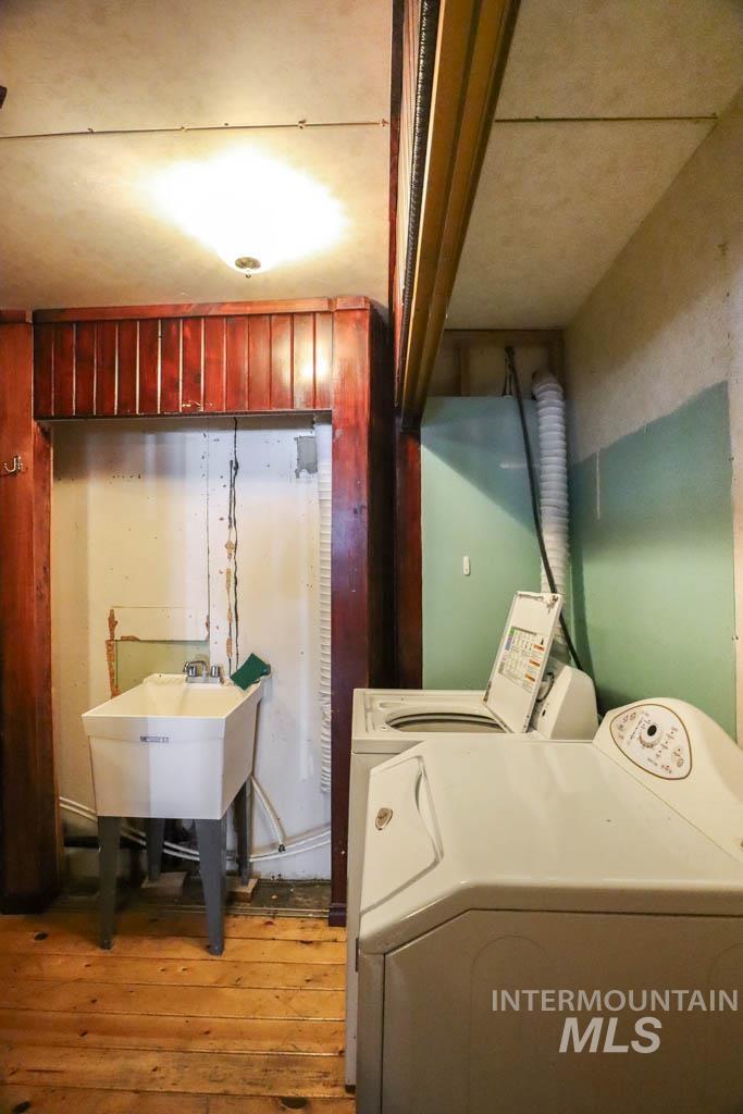 Laundry area with light wood-style floors and washer and clothes dryer