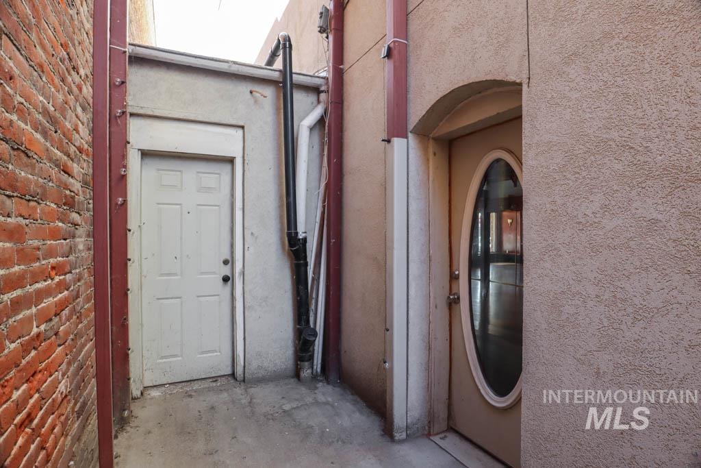 Property entrance with stucco siding and brick siding