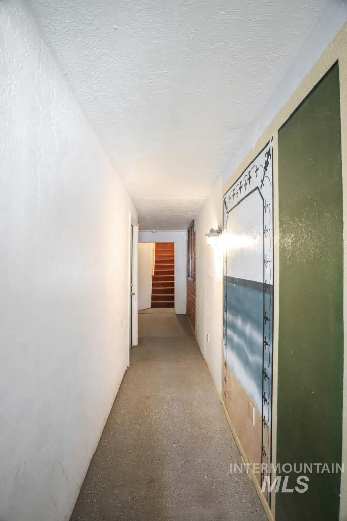 Hallway with a textured ceiling and stairs