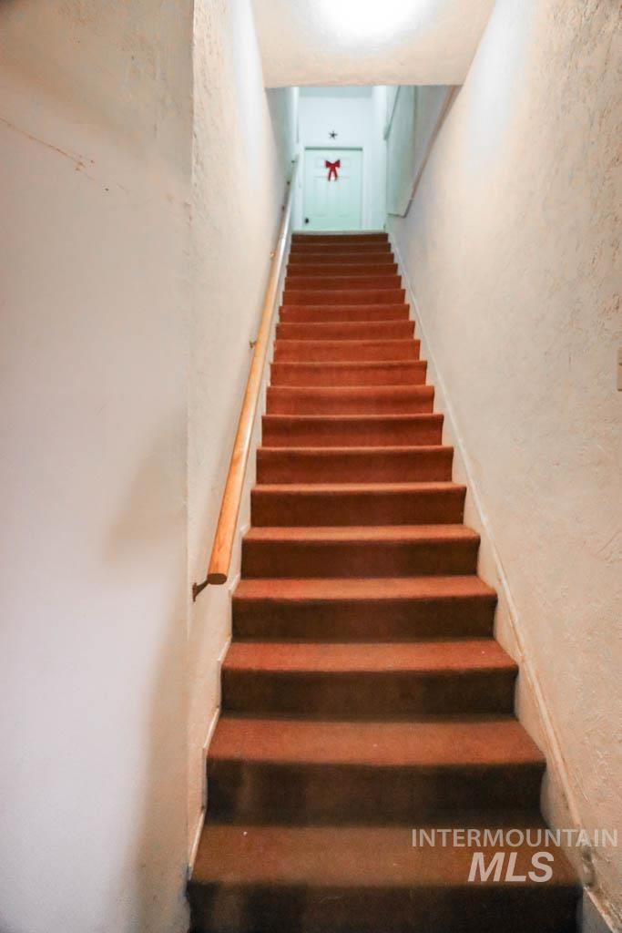 Stairway featuring a textured wall