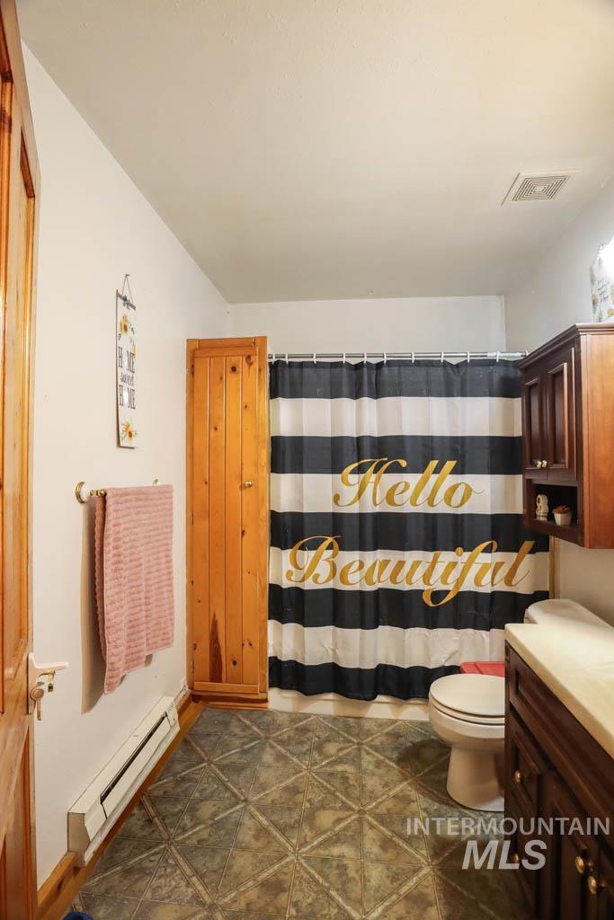 Bathroom featuring a baseboard heating unit and vanity