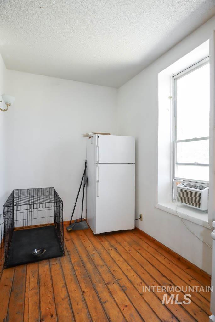 Washroom featuring a textured ceiling, hardwood / wood-style floors, and cooling unit