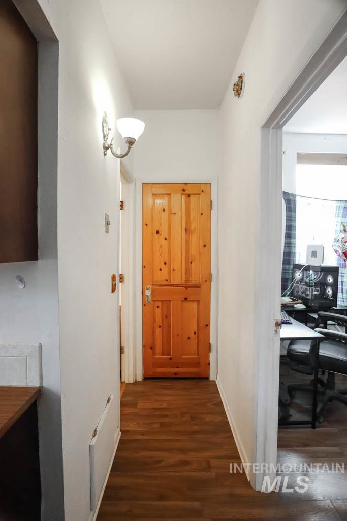 Hall featuring a desk and dark wood-type flooring
