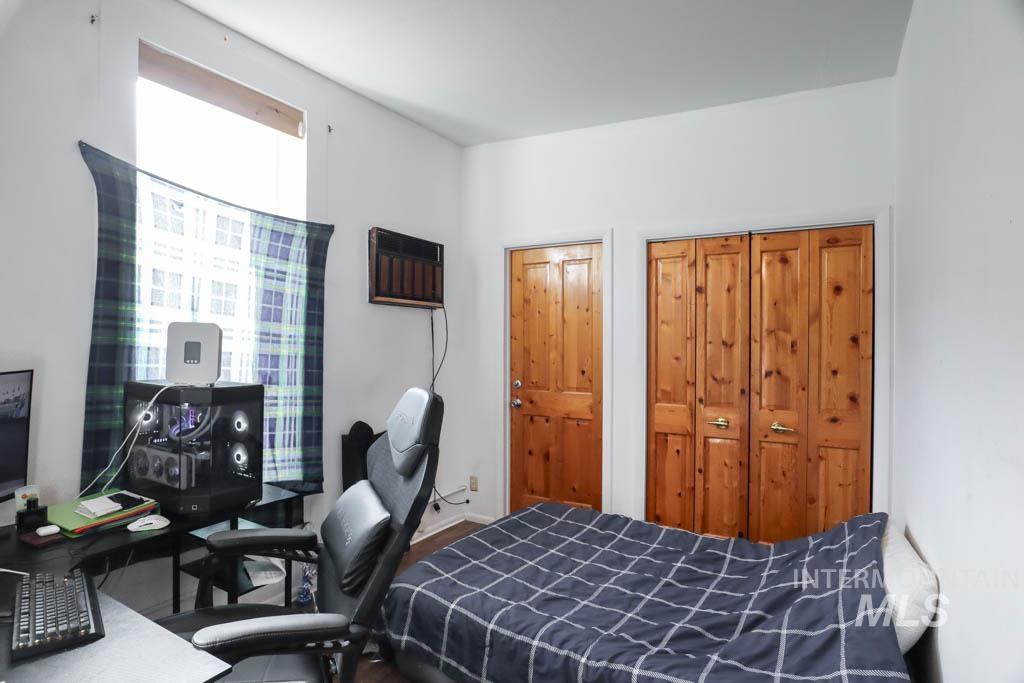 Bedroom featuring an office area, an AC wall unit, and a closet